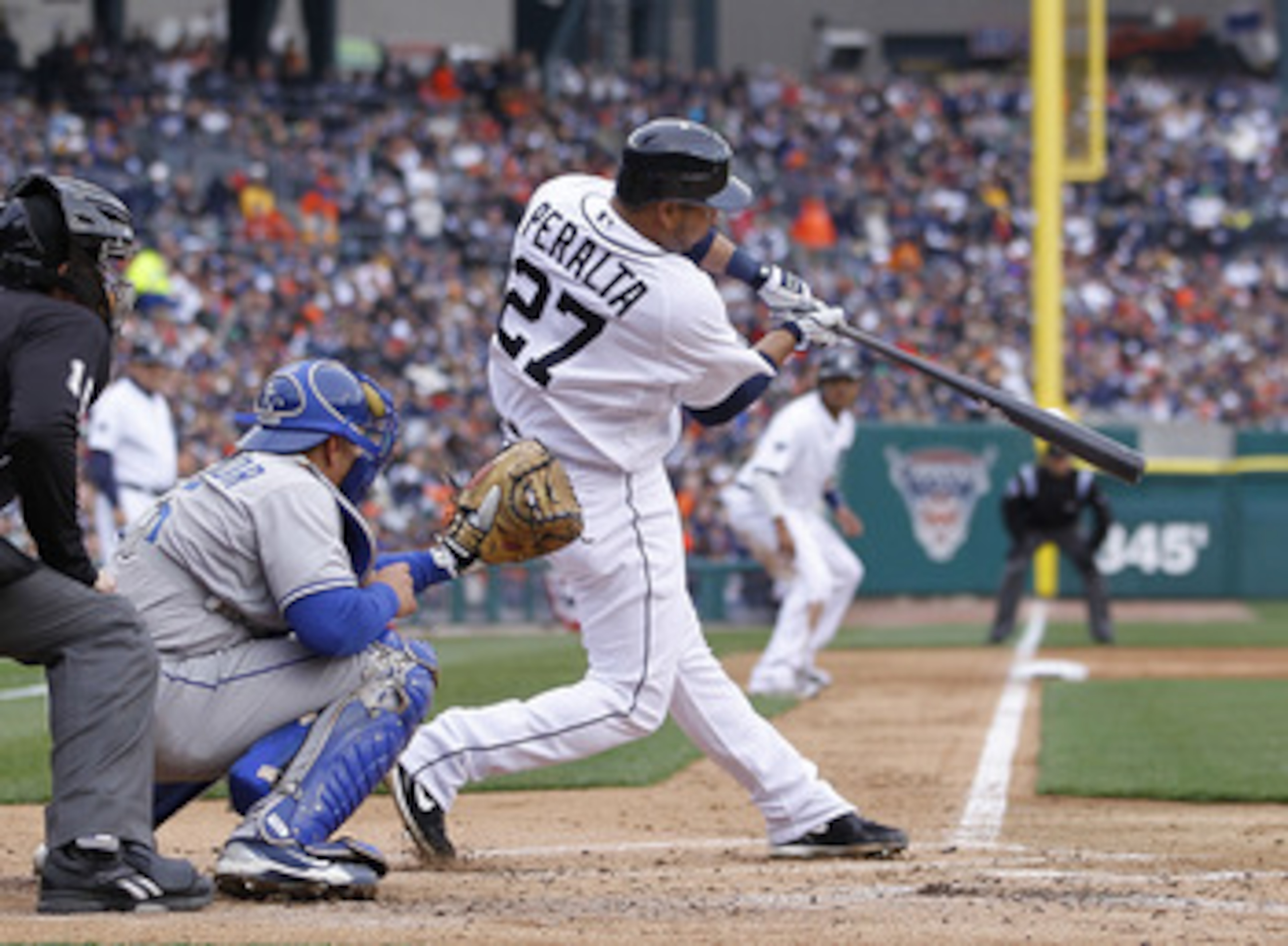 DETROIT, MI - APRIL 08:  Jhonny Peralta #27 of the Detroit Tigers hits a first inning RBI in front of Matt Treanor #15 of the Kansas City Royals during Opening Day at Comerica Park on April 8, 2011 in Detroit, Michigan.  (Photo by Gregory Shamus/Getty Ima
