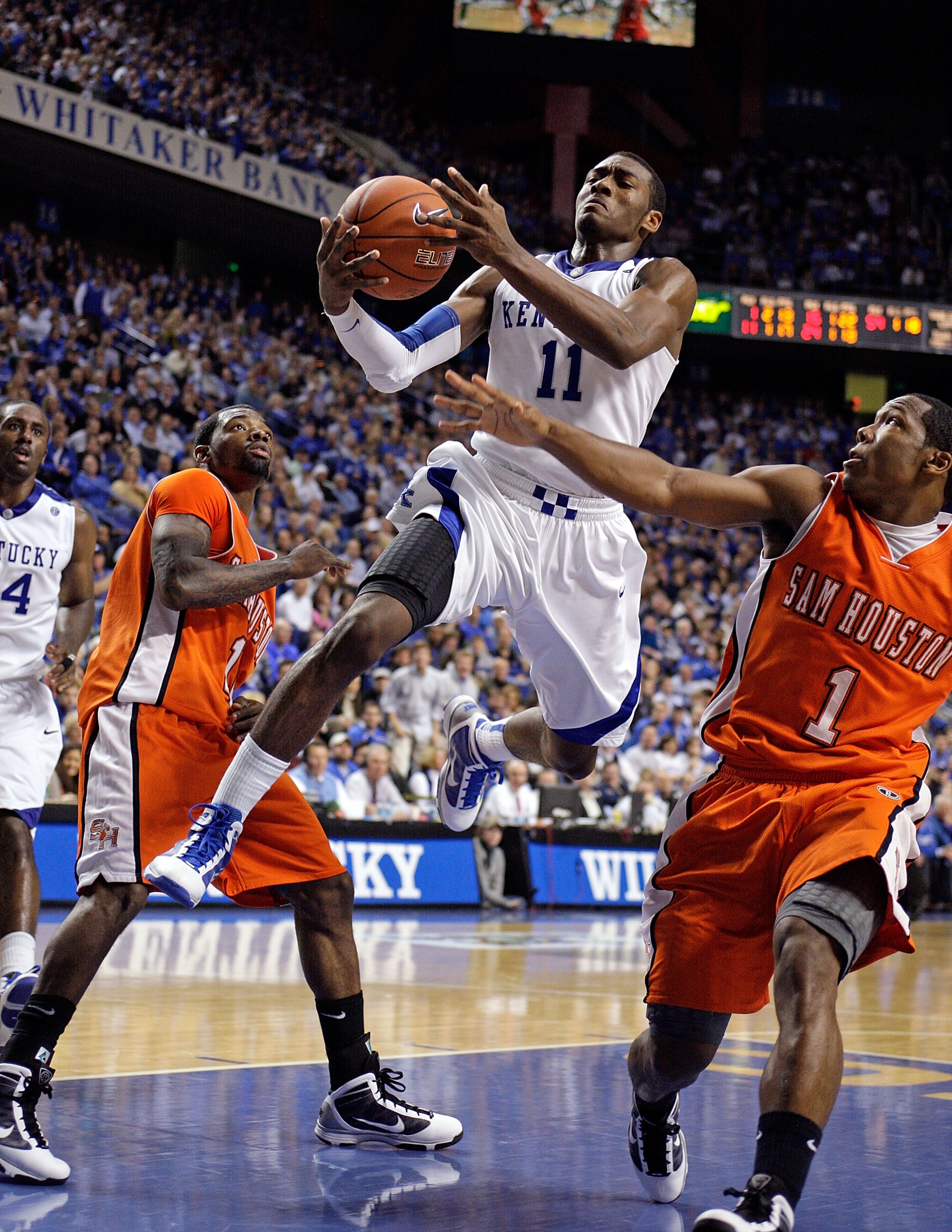 LEXINGTON, KY - NOVEMBER 19:  John Wall #11 of the Kentucky Wildcats is fouled by by Ashton Mitchell #1 of the Sam Houston State Bearkats during the game at Rupp Arena on November 19, 2009 in Lexington, Kentucky.  (Photo by Andy Lyons/Getty Images)