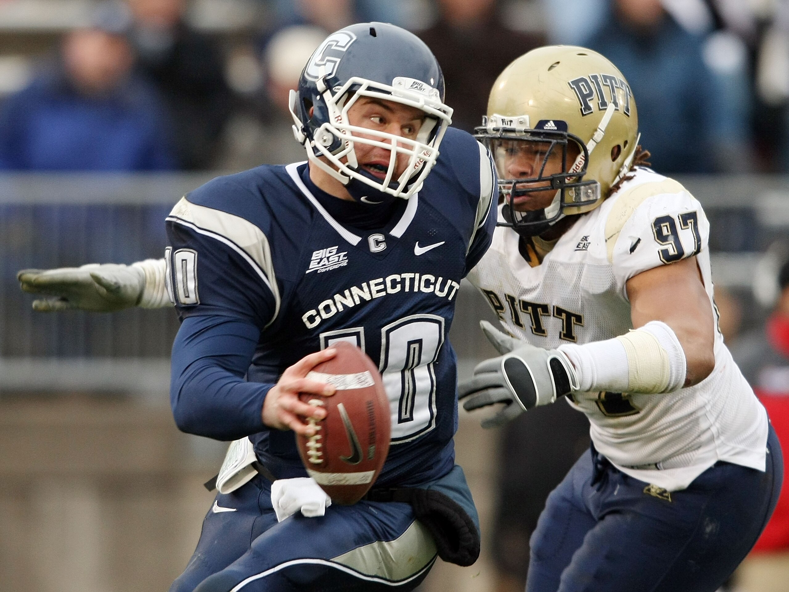 EAST HARTFORD, CT - DECEMBER 06:  Zach Frazer #10 of the Connecticut Huskies narrowly escapes Jabaal Sheard #97 of the Pittsburgh Panthers on December 6, 2008 at Rentschler Field in East Hartford, Connecticut. The Panthers defeated the Huskies 34-10.  (Ph