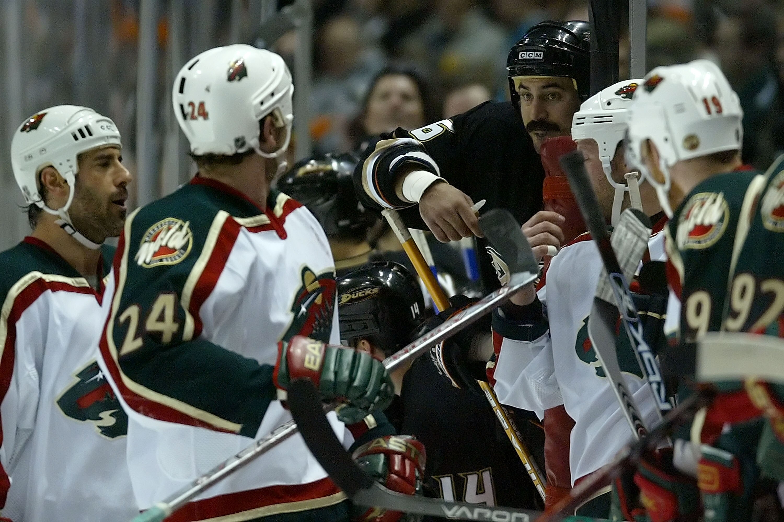 ANAHEIM, CA - APRIL 19:  George Parros #16 of the Anaheim Ducks exchanges words from the bench with (L) Derek Boogaard #24 of the Minnesota Wild in the first period during game five of the 2007 Western Conference Quarterfinals at Honda Center on April 19,