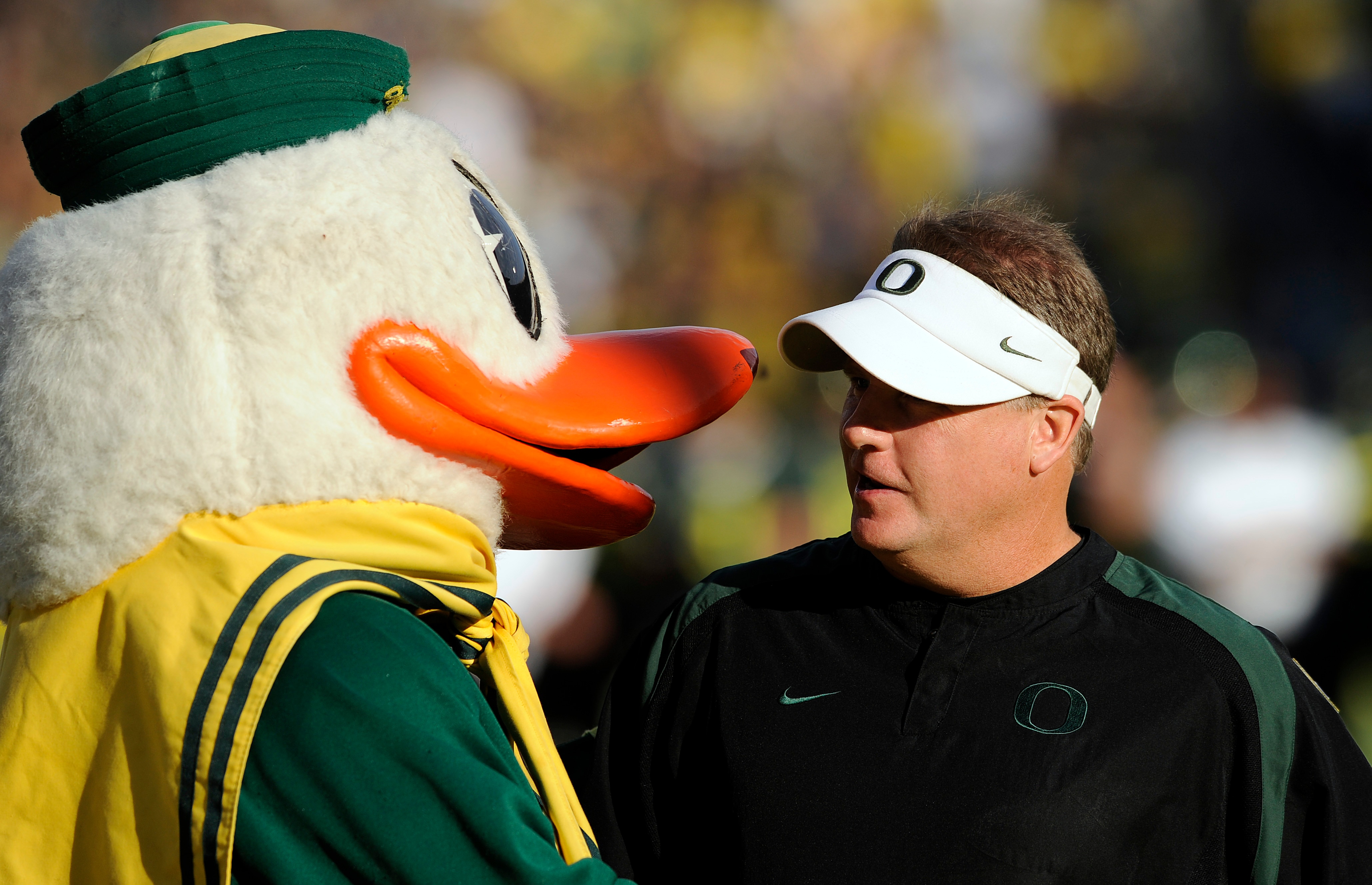 EUGENE, OR - OCTOBER 2: Head coach Chip Kelly of the Oregon Ducks is greeted by 'Puddles', the mascot of the Oregon Ducks, before the game against the Stanford Cardinal at Autzen Stadium on October 2, 2010 in Eugene, Oregon. Oregon won the game 52-31. (Ph