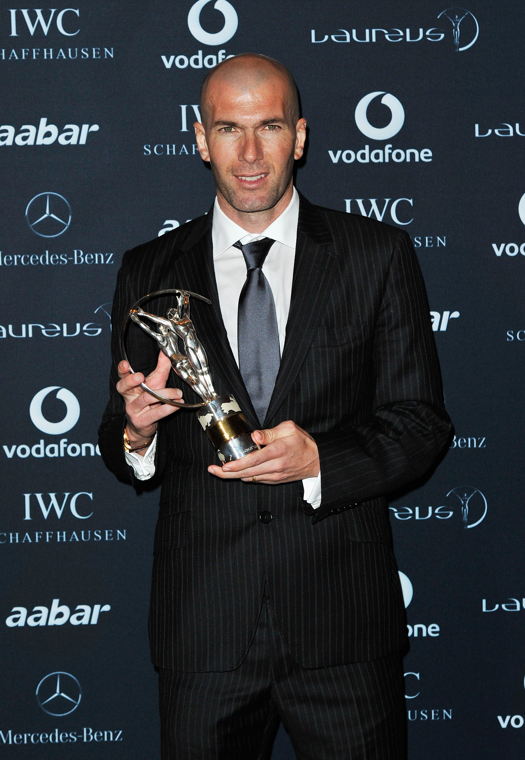 ABU DHABI, UNITED ARAB EMIRATES - FEBRUARY 07: Zinedine Zidane poses with the Laureus Lifetime Achievement award at the winners photocall at the 2011 Laureus World Sports Awards at the Emirates Palace on February 7, 2011 in Abu Dhabi, United Arab Emirates