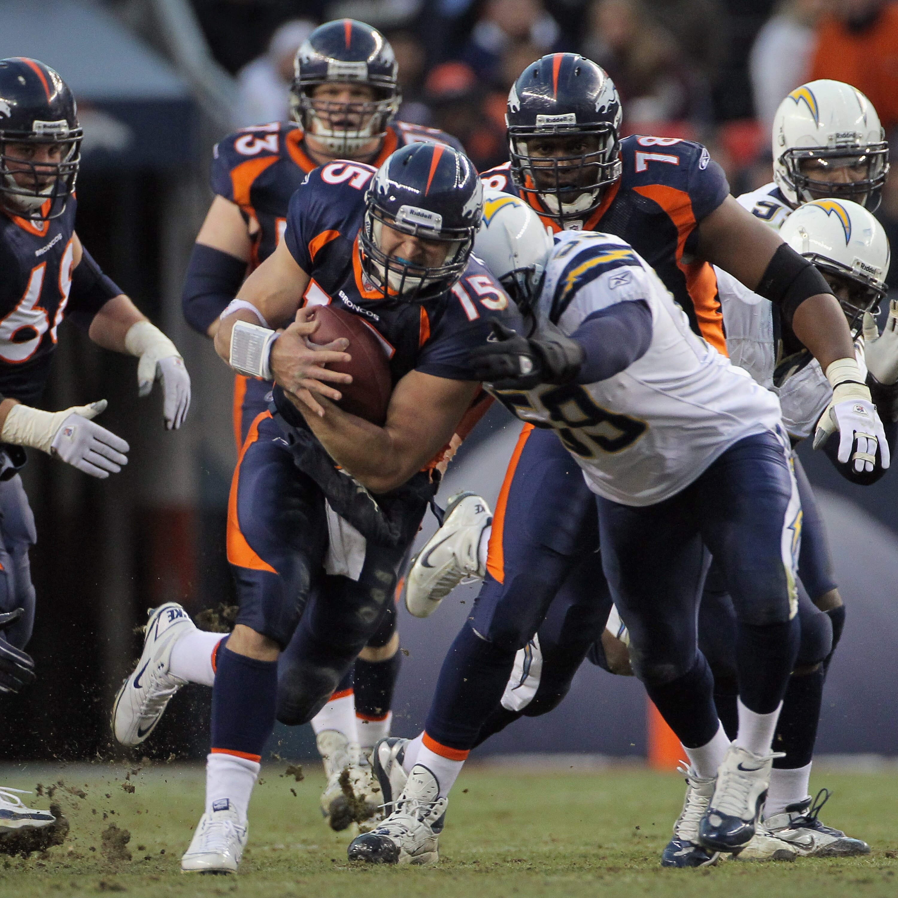 DENVER - JANUARY 02:  Quarterback Tim Tebow #15 of the Denver Broncos rushes with the ball as linebacker Brandon Siler #59 of the San Diego Chargers makes the tackle at INVESCO Field at Mile High on January 2, 2011 in Denver, Colorado. The Chargers defeat