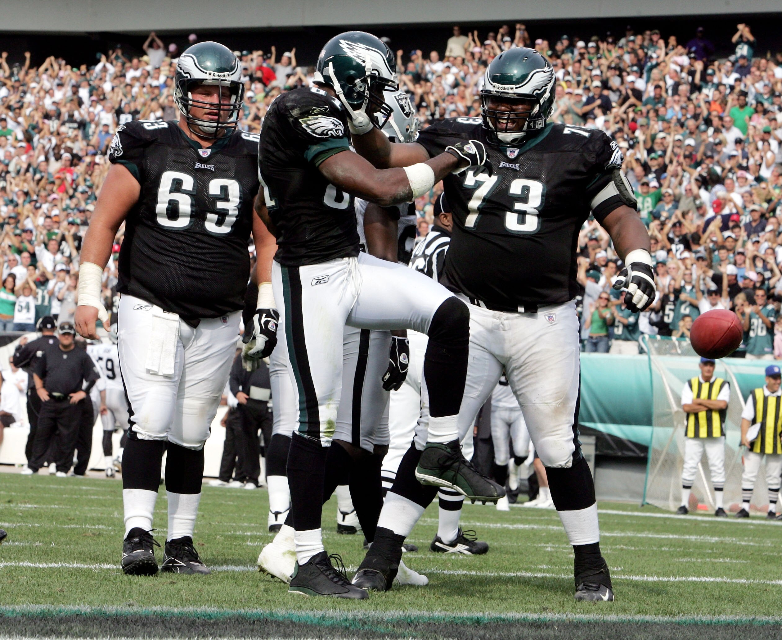 PHILADELPHIA - SEPTEMBER 25:  Wide receiver Terrell Owens #81 of the Philadelphia Eagles kicks the ball away as he celebrates his touchdown with teammates Hank Fraley #63 and Shawn Andrews #73 during the third quarter of their game against the Oakland Rai