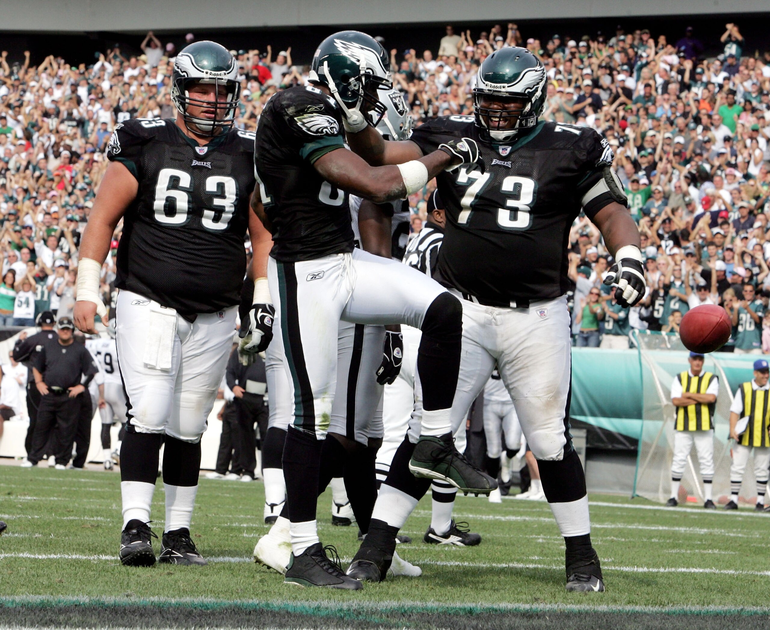 PHILADELPHIA - SEPTEMBER 25:  Wide receiver Terrell Owens #81 of the Philadelphia Eagles kicks the ball away as he celebrates his touchdown with teammates Hank Fraley #63 and Shawn Andrews #73 during the third quarter of their game against the Oakland Rai