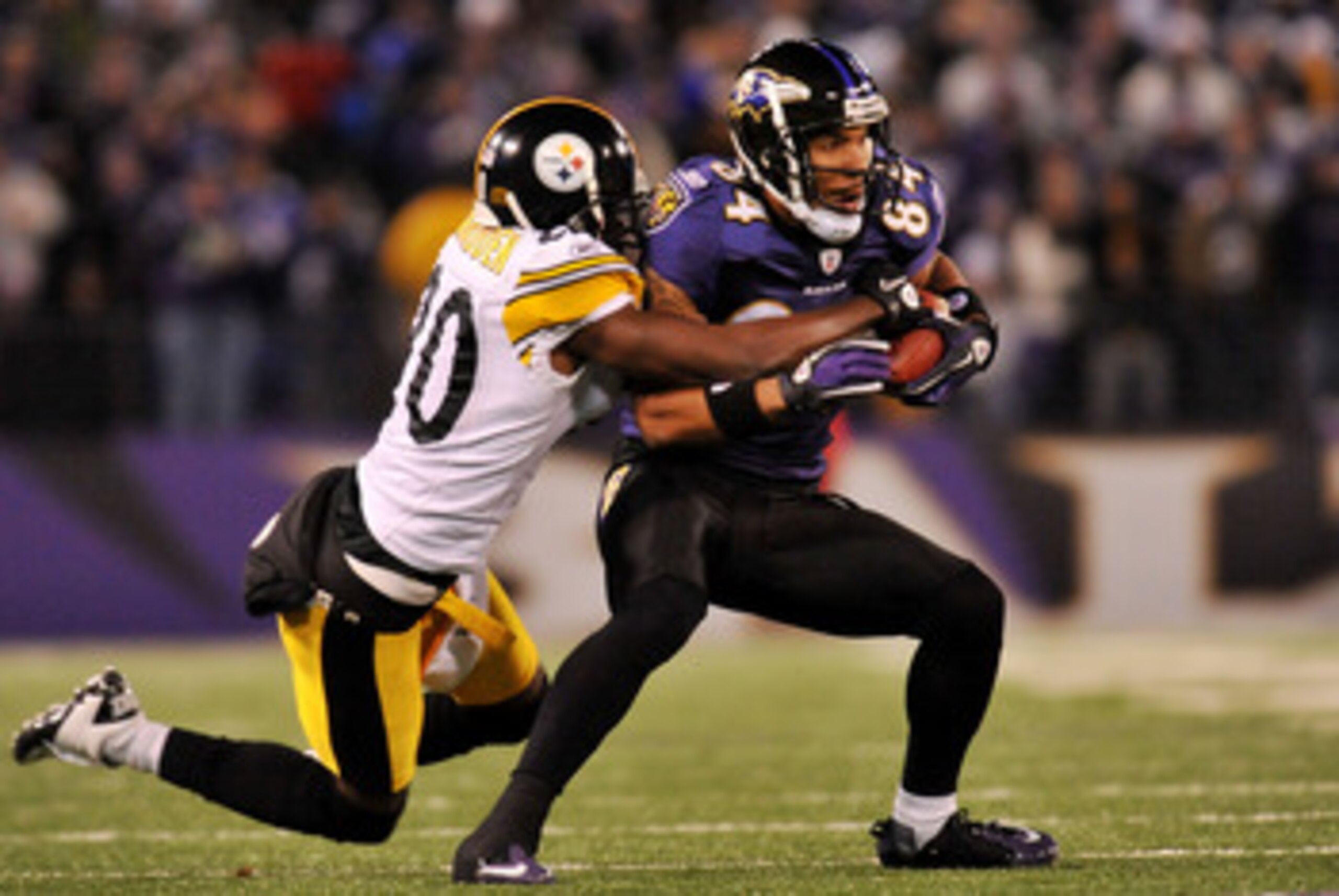 BALTIMORE, MD - DECEMBER 05:  T.J. Houshmandzadeh #84 of the Baltimore Ravens runs the ball against Bryant McFadden #20 of the Pittsburgh Steelers during the first half of the game at M&T Bank Stadium on December 5, 2010 in Baltimore, Maryland. Pittsburgh