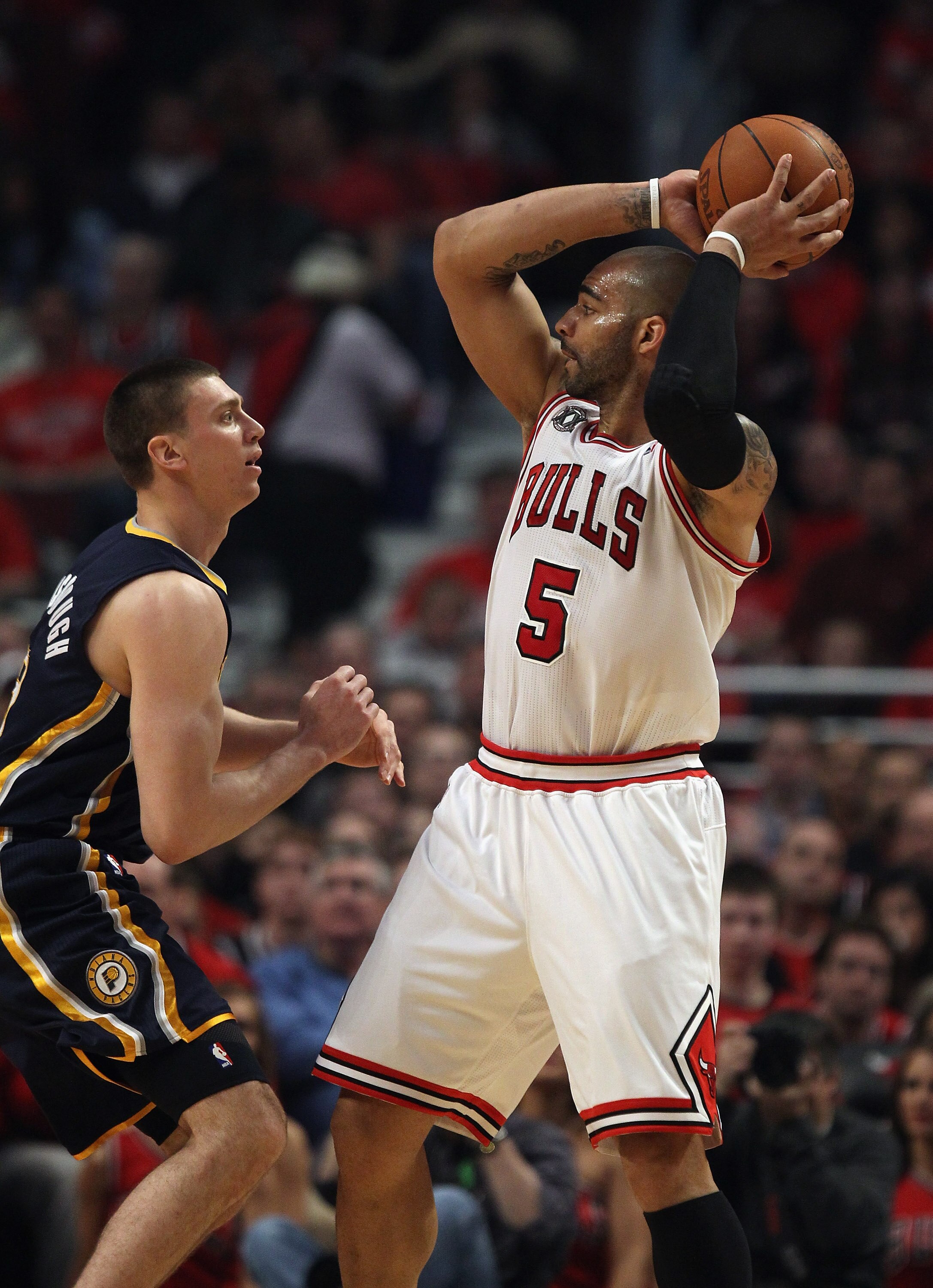 CHICAGO, IL - APRIL 16: Carlos Boozer #5 of the Chicago Bulls looks to pass over Tyler Hansbrough #50 of the Indiana Pacers in Game One of the Eastern Conference Quarterfinals in the 2011 NBA Playoffs at the United Center on April 16, 2011 in Chicago, Ill