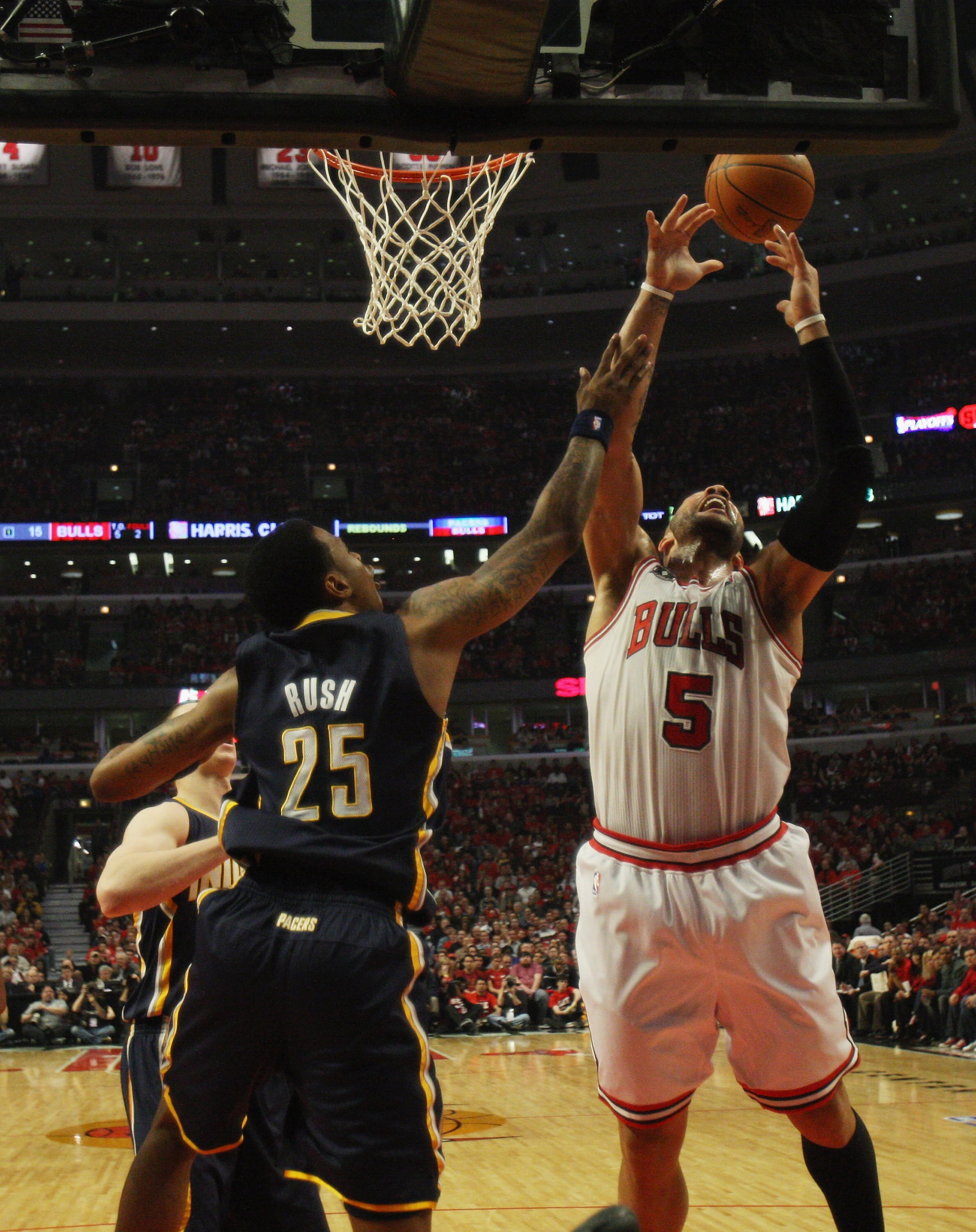 CHICAGO, IL - APRIL 16: Carlos Boozer #5 of the Chicago Bulls leaps for a rebound over Brandon Rush #25 of the Indiana Pacers in Game One of the Eastern Conference Quarterfinals in the 2011 NBA Playoffs at the United Center on April 16, 2011 in Chicago, I