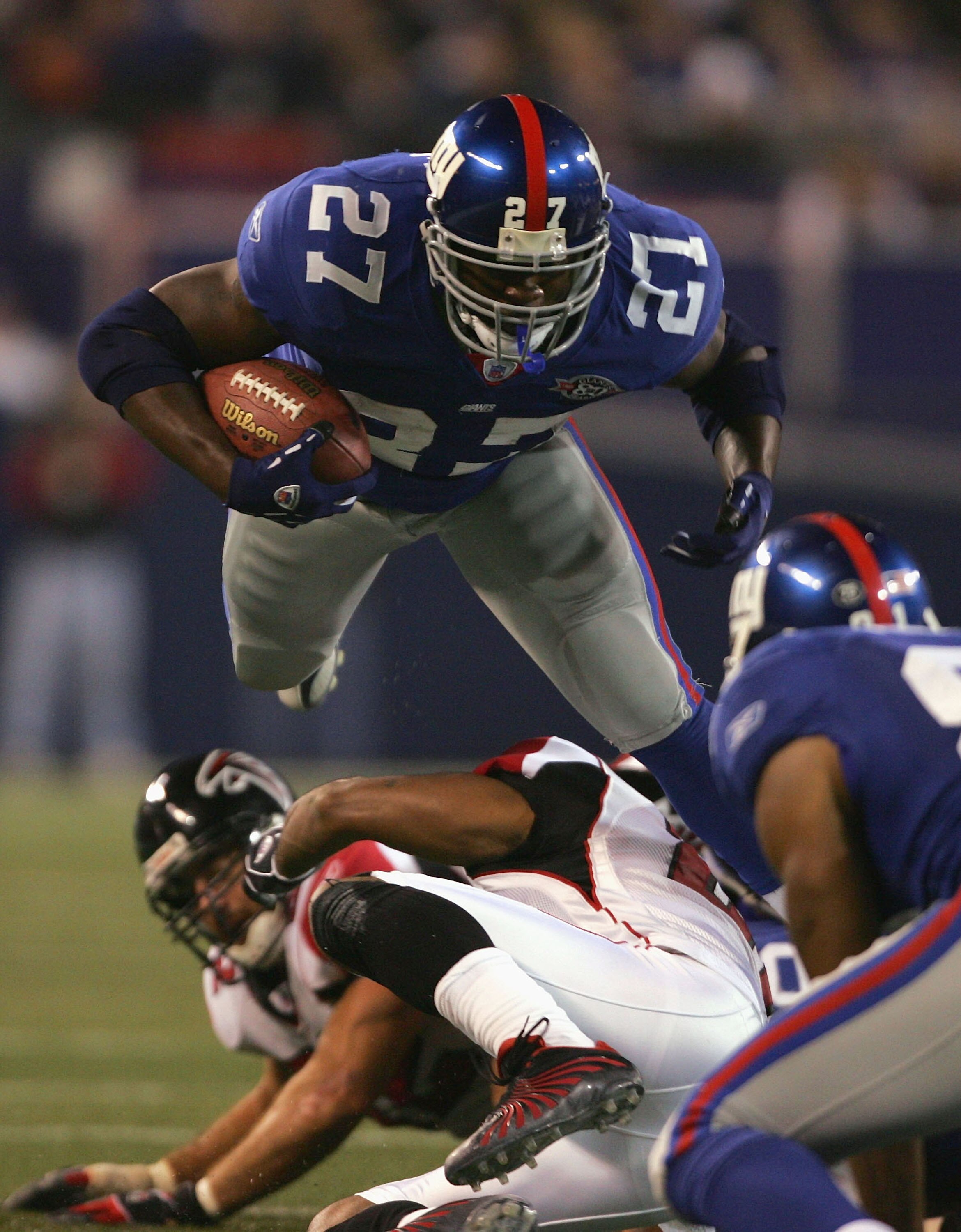 EAST RUTHERFORD, NJ - NOVEMBER 21:  Running back Ron Dayne #27 of the New York Giants is hit by cornerback DeAngelo Hall #21 of the Atlanta Falcons in the third quarter at Giants Stadium on November 21, 2004 in East Rutherford, New Jersey.  The Falcons de