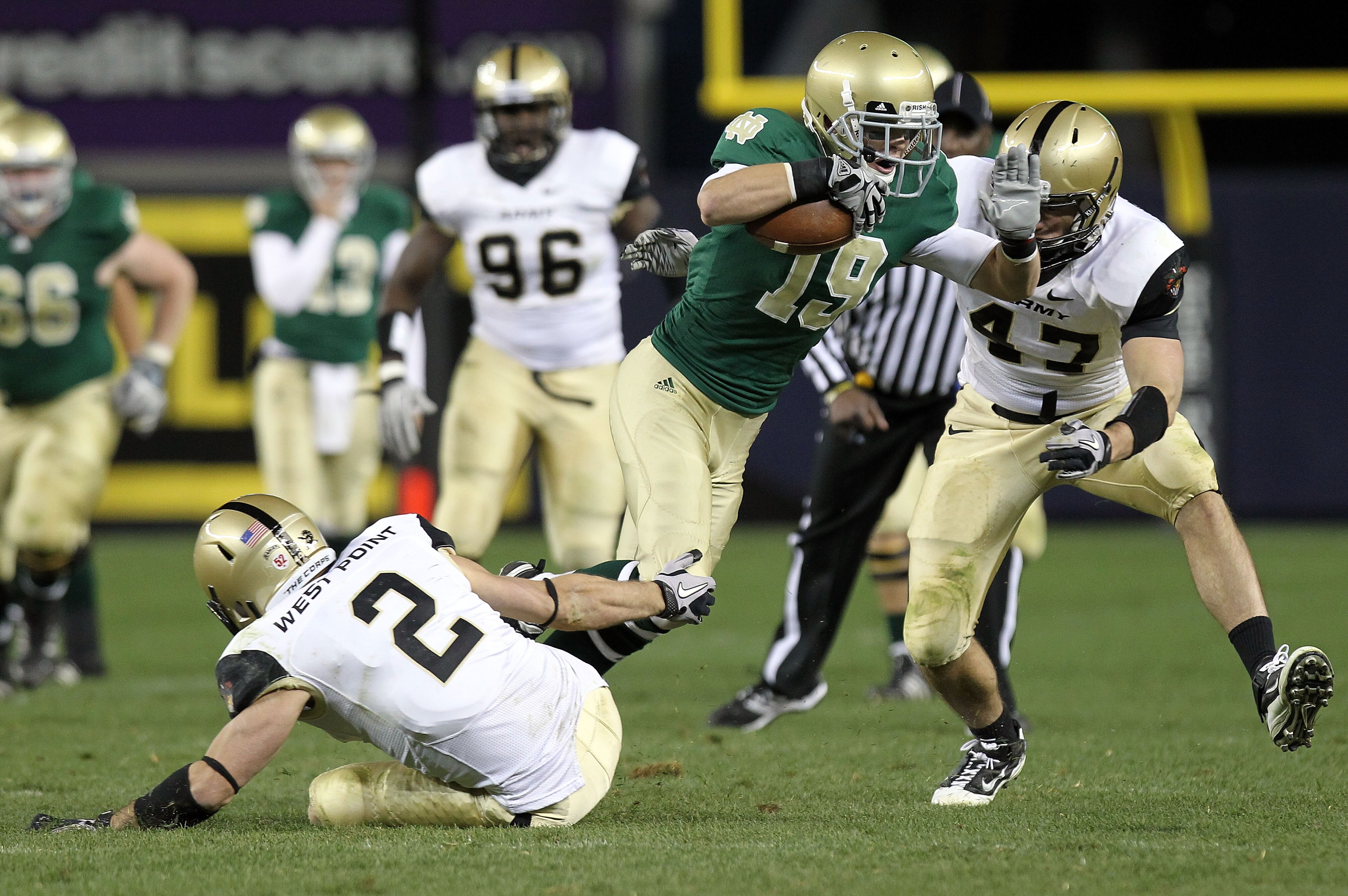 NEW YORK - NOVEMBER 20: Robby Toma #19 of the Notre Dame Fighting Irish is tackled by Richard King #2 and Bill Prosko #47 of the Army Black Knights at Yankee Stadium on November 20, 2010 in the Bronx borough of New York City.  (Photo by Nick Laham/Getty I