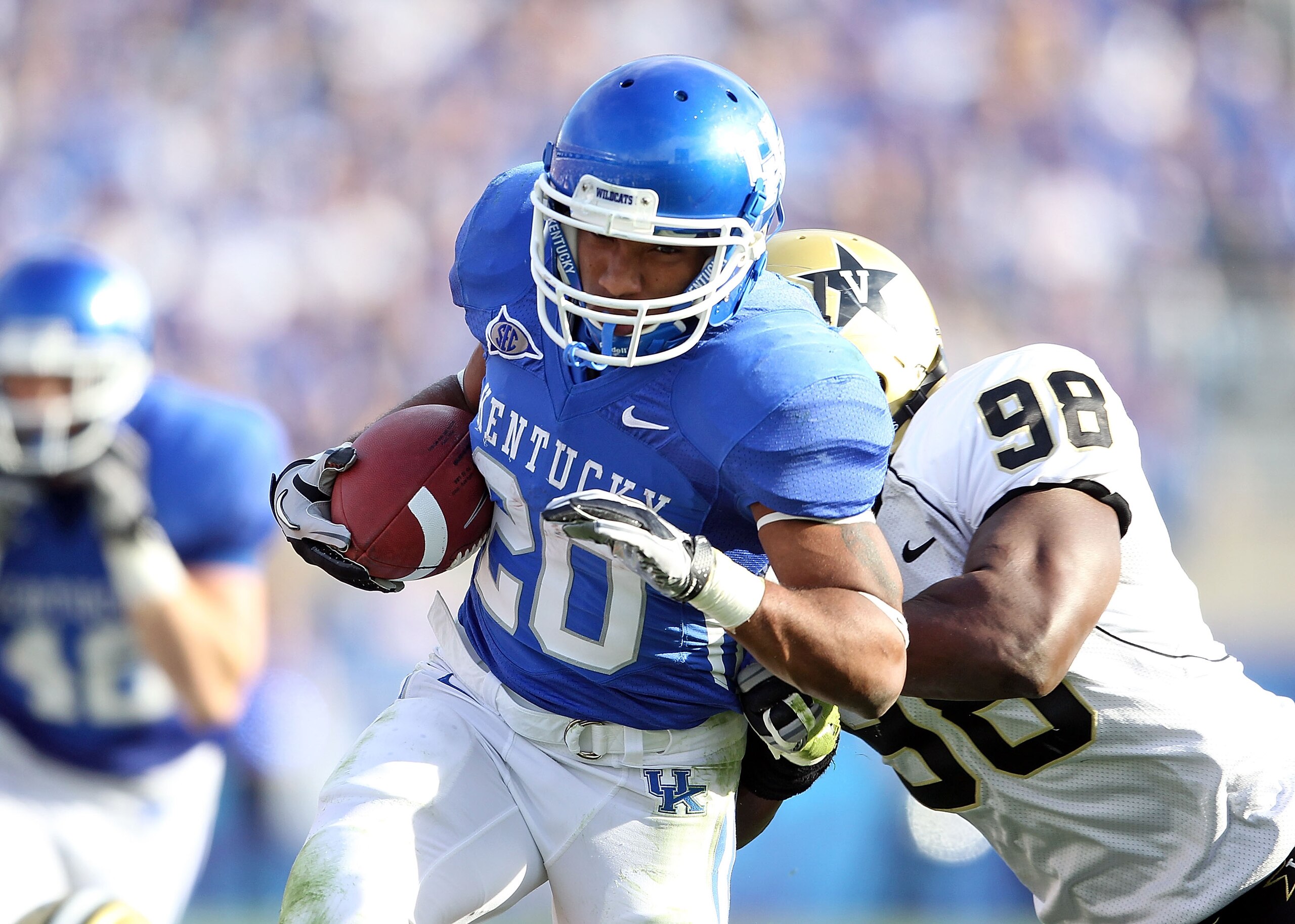 LEXINGTON, KY - NOVEMBER 13: Derrick Locke #20 of the Kentucky Wildcats runs with the ball while defended by Johnell Thomas #98 of the Vanderbilt Commodores during the game at Commonwealth Stadium on November 13, 2010 in Lexington, Kentucky. Kentucky won LEXINGTON, KY - NOVEMBER 13: Derrick Locke #20 of the Kentucky Wildcats runs with the ball while defended by Johnell Thomas #98 of the Vanderbilt Commodores during the game at Commonwealth Stadium on November 13, 2010 in Lexington, Kentucky. Kentucky won