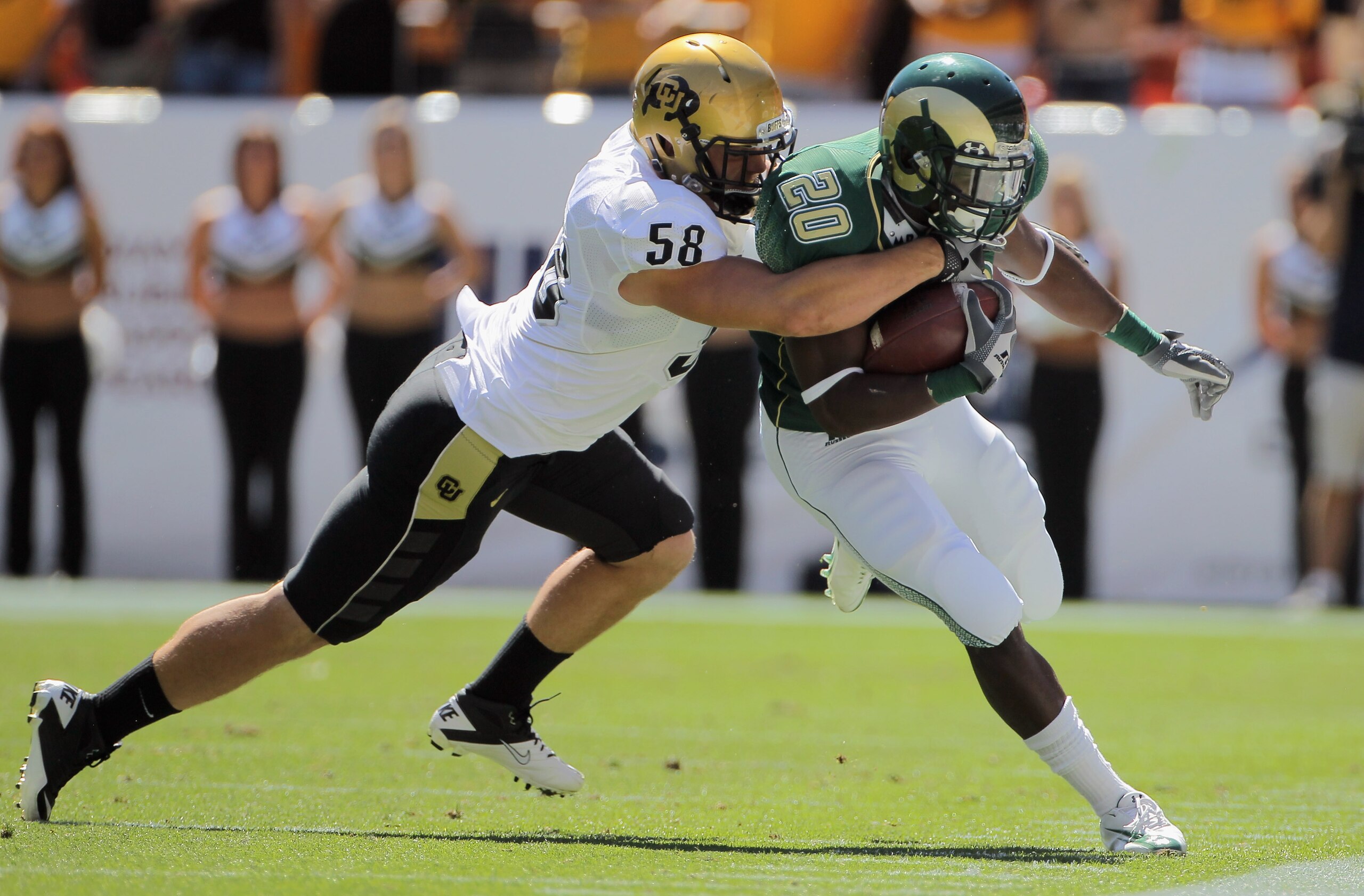 DENVER - SEPTEMBER 04:  Running back Raymond Carter #20 of the Colorado State Rams makes a pass reception and is stopped by linebacker Tyler Ahles #58 of the Colorado Buffaloes during the the Rocky Mountain Showdown at INVESCO Field at Mile High on Septem