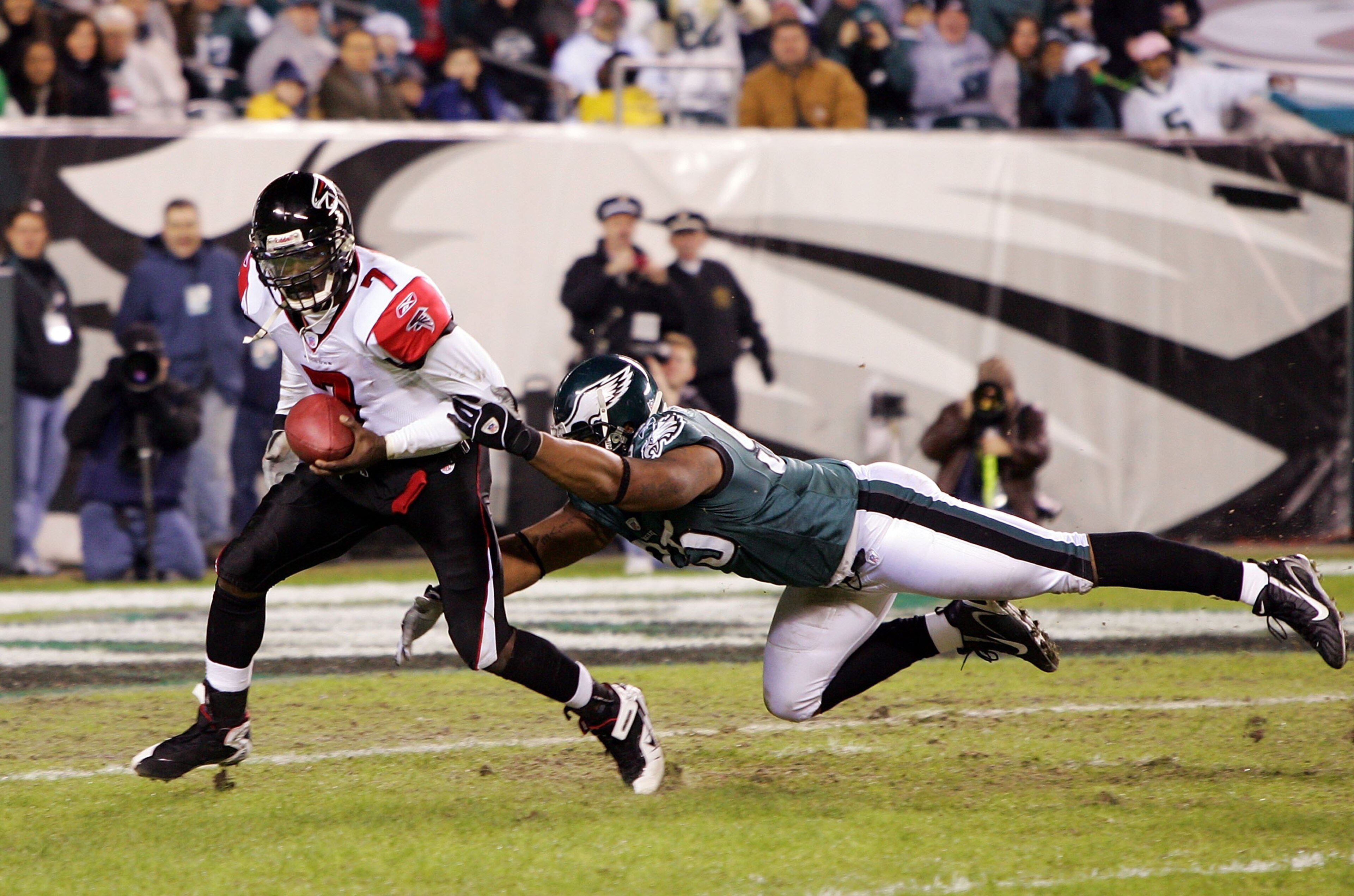 PHILADELPHIA - DECEMBER 31: Michael Vick #7 of the Atlanta Falcons eludes a tackle by Jerome McDougle #95 of the Philadelphia Eagles in NFL action December 31, 2006 at Lincoln Financial Field in Philadelphia, Pennsylvania. The Eagles won 24-17. (Photo b PHILADELPHIA - DECEMBER 31: Michael Vick #7 of the Atlanta Falcons eludes a tackle by Jerome McDougle #95 of the Philadelphia Eagles in NFL action December 31, 2006 at Lincoln Financial Field in Philadelphia, Pennsylvania. The Eagles won 24-17. (Photo b