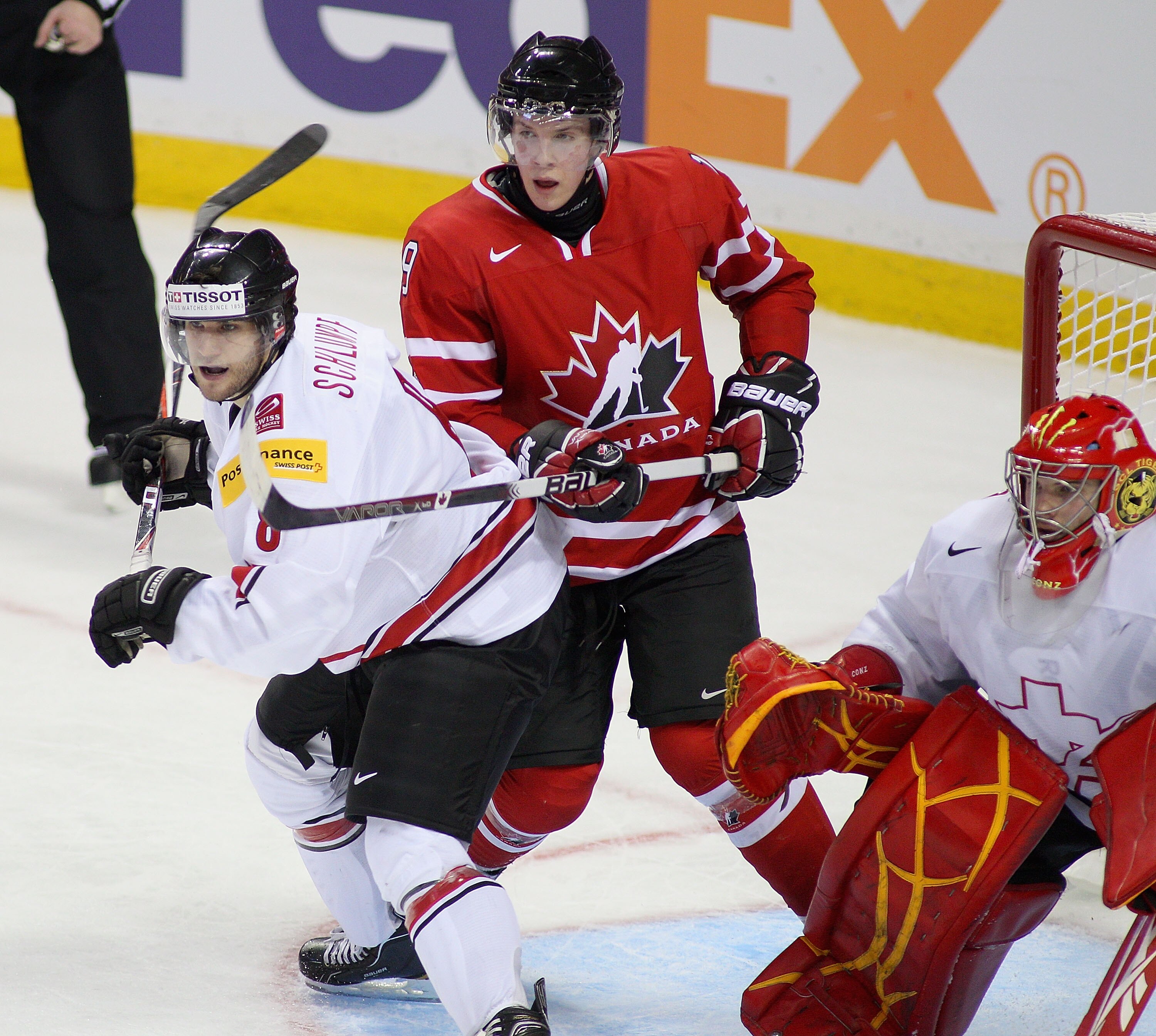 BUFFALO, NY - JANUARY 02: Dominik Schlumpf #8 and Benjamin Conz #1 of Switzerland defend against Ryan Johansen #19 of Canada  during the 2011 IIHF World U20 Championship game between Canada and Switzerland on January 2, 2011 in Buffalo, New York. Canada w