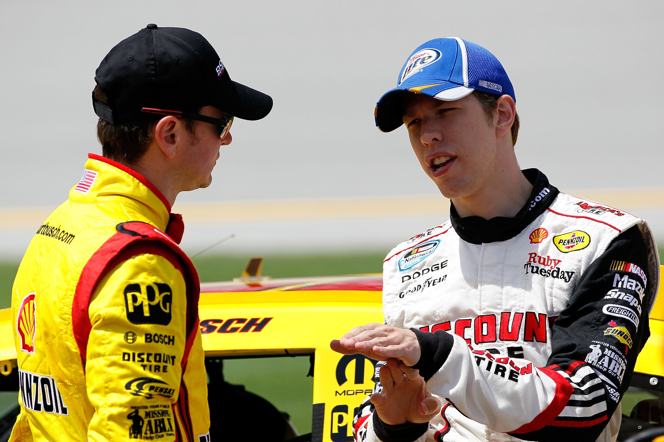 TALLADEGA, AL - APRIL 16:  Kurt Busch (L), driver of the #22 Shell/Pennzoil-AAA Dodge, talks with Brad Keselowski (R), driver of the #2 Miller Lite Dodge, on the grid during qualifying for the NASCAR Sprint Cup Series Aaron's 499 at Talladega Superspeedwa