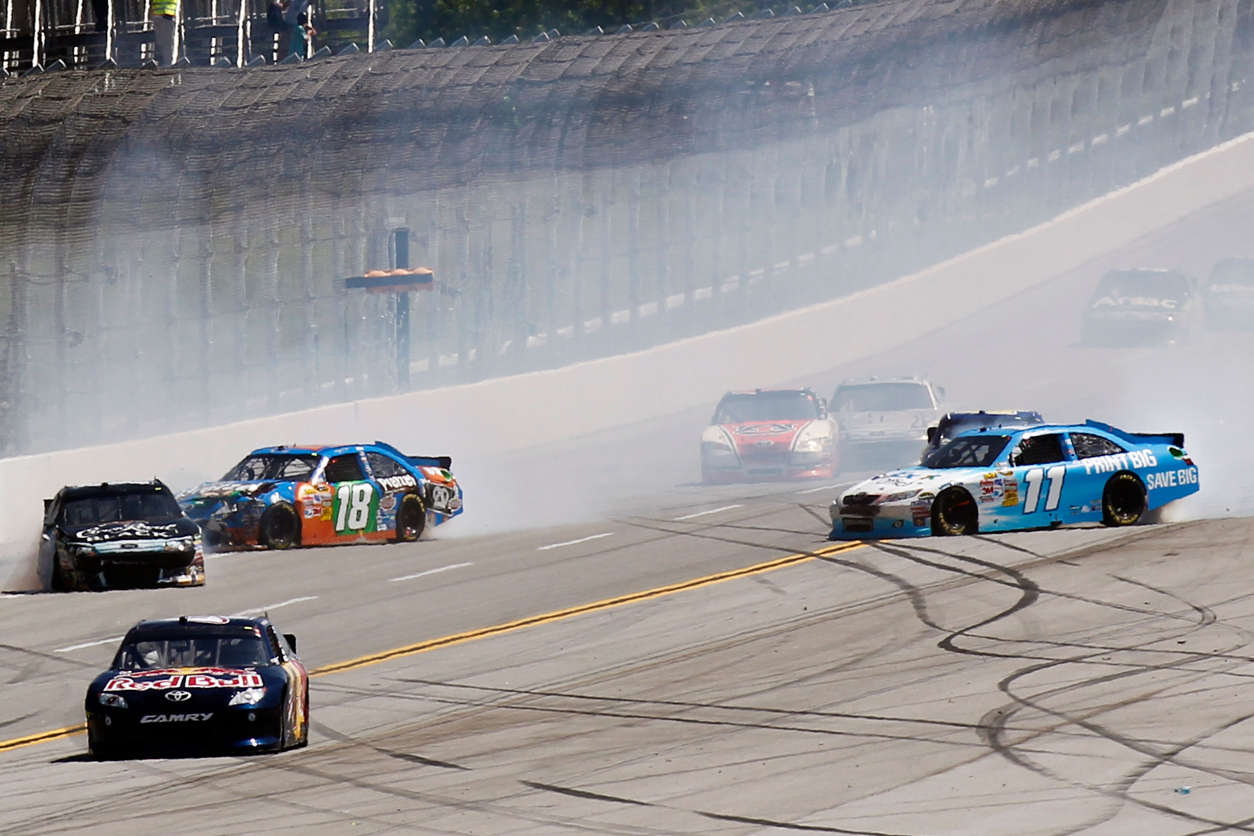 TALLADEGA, AL - APRIL 17:  Kyle Busch, driver of the #18 M&M's Pretzel Toyota, Denny Hamlin, driver of the #11 FedEx Office Toyota, and Matt Kenseth, driver of the #17 Crown Royal Black Ford, spin out after an incident in the NASCAR Sprint Cup Series Aaro