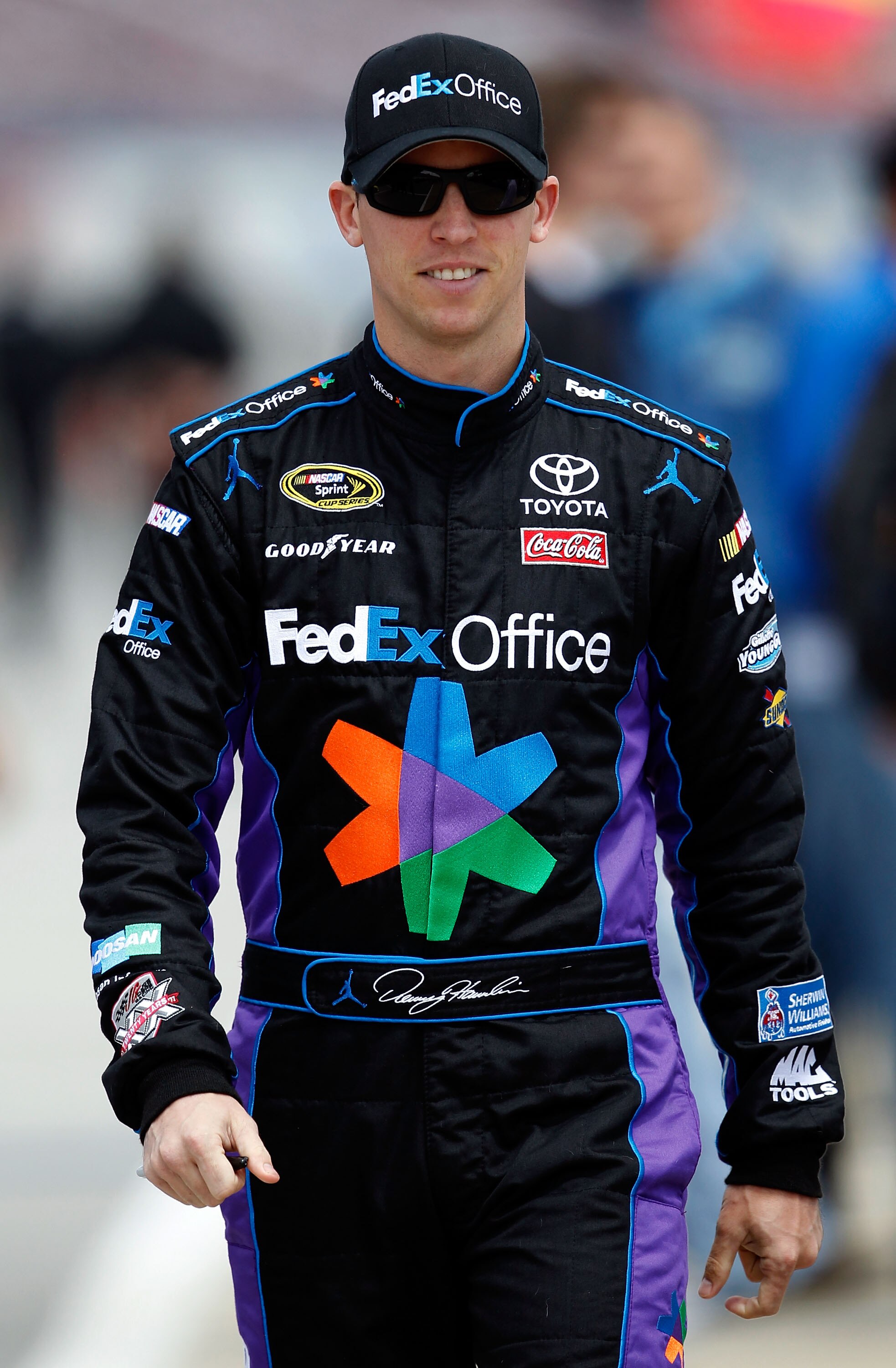TALLADEGA, AL - APRIL 16:  Denny Hamlin, driver of the #11 FedEx Office Toyota, walks on the grid during qualifying for the NASCAR Sprint Cup Series Aaron's 499 at Talladega Superspeedway on April 16, 2011 in Talladega, Alabama.  (Photo by Tom Pennington/