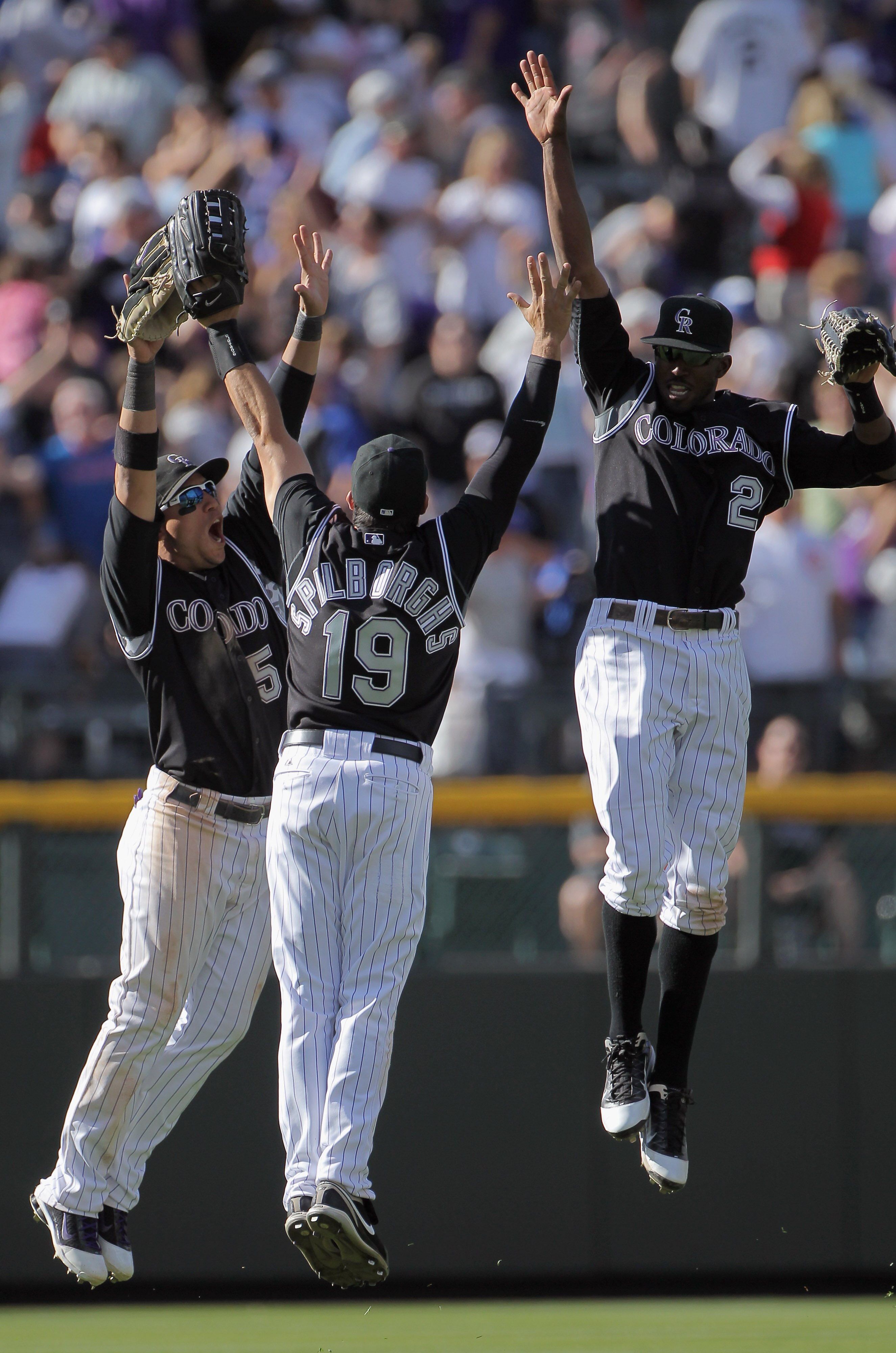 DENVER, CO - APRIL 17:  Outfielders Carlos Gonzalez #5, Ryan Spilborghs #19 and Dexter Fowler #24 of the Colorado Rockies celebrate after the Rockies 9-5 win over the Chicago Cubs at Coors Field on April 17, 2011 in Denver, Colorado.  (Photo by Doug Pensi