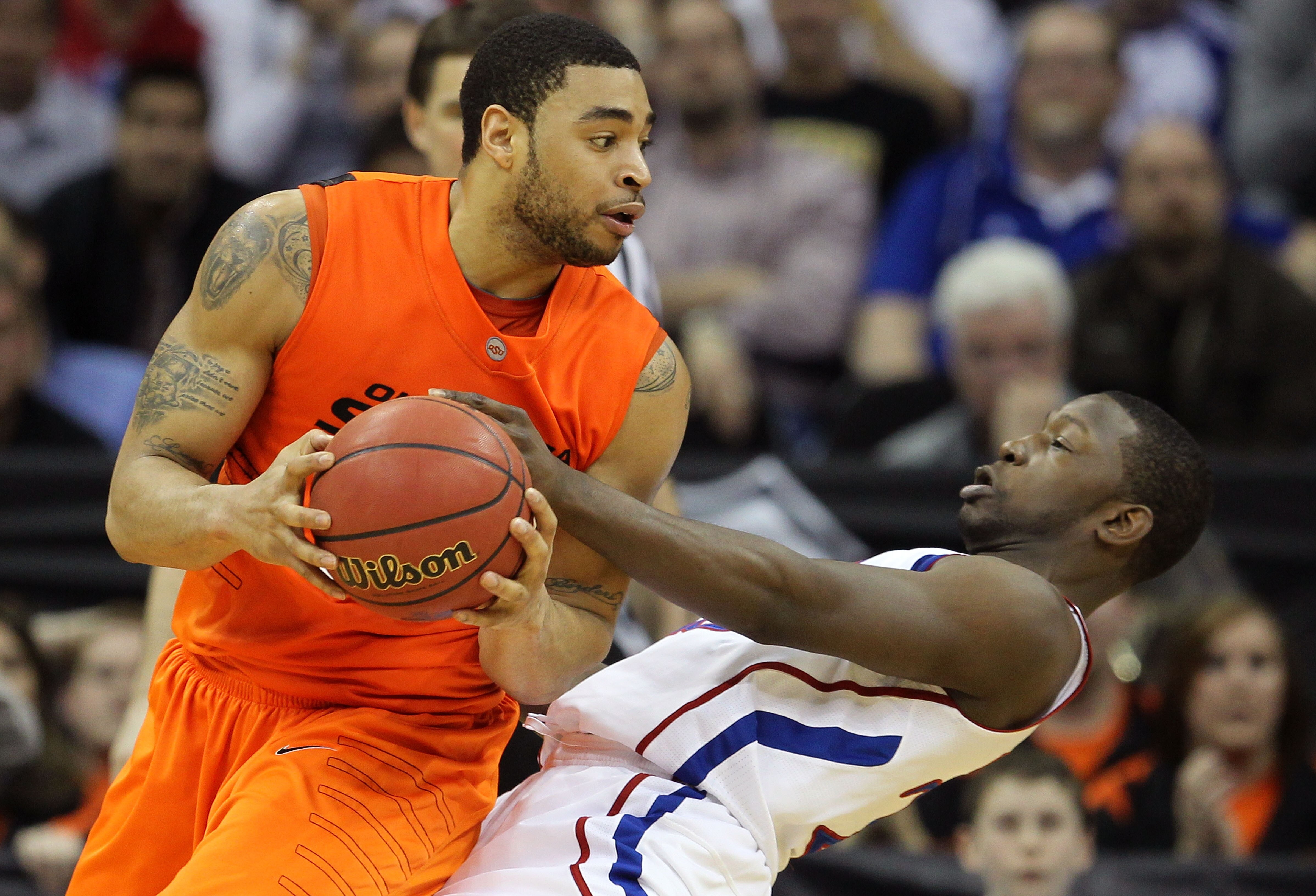 KANSAS CITY, MO - MARCH 10:  Marshall Moses #33 of the Oklahoma State Cowboys drives with the ball on Mario Little #23 of the Kansas Jayhawks during their quarterfinal game in the 2011 Phillips 66 Big 12 Men's Basketball Tournament at Sprint Center on Mar