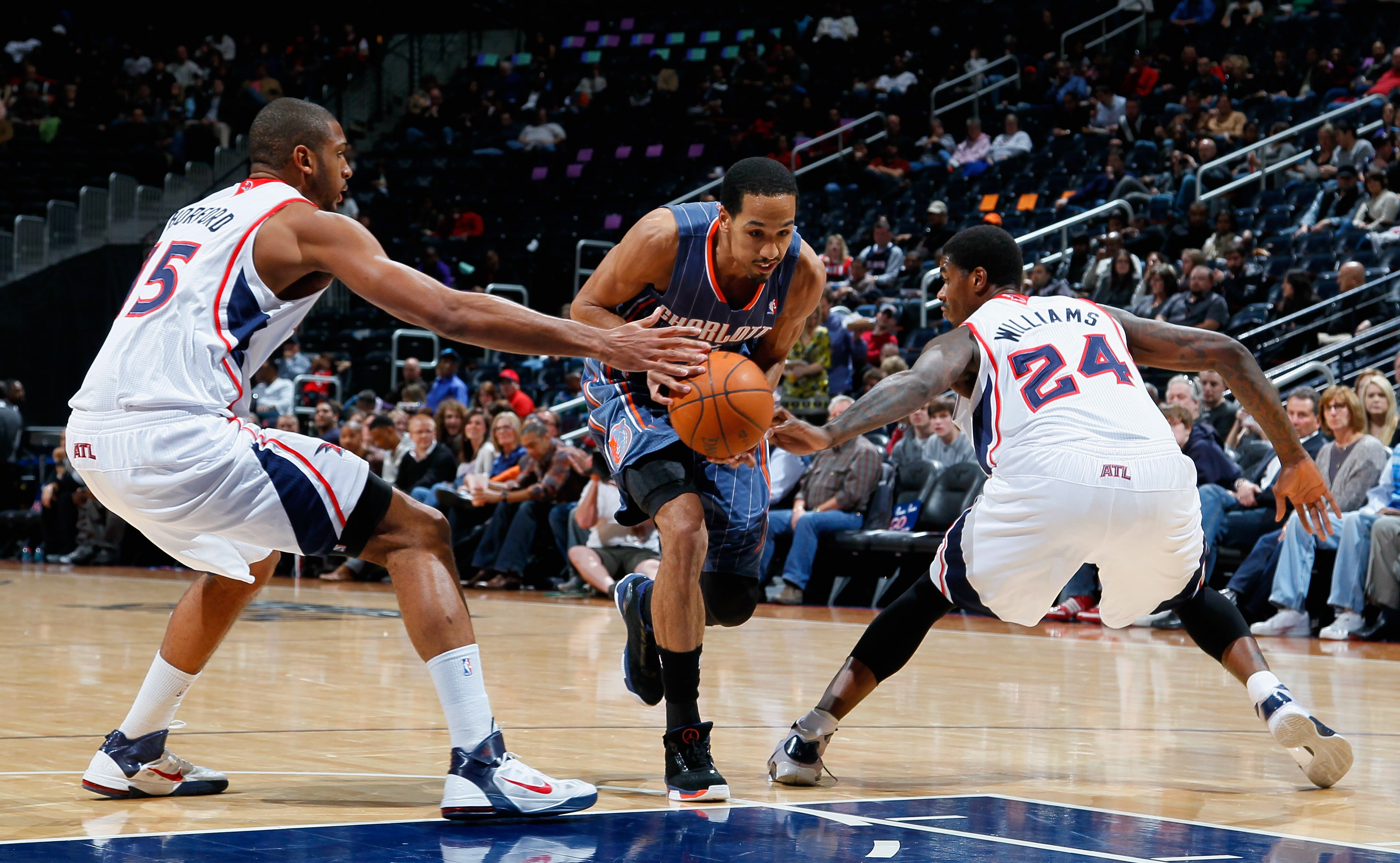 ATLANTA, GA - FEBRUARY 12:  Shaun Livingston #2 of the Charlotte Bobcats drives between Al Horford #15 and Marvin Williams #24 of the Atlanta Hawks at Philips Arena on February 12, 2011 in Atlanta, Georgia.  NOTE TO USER: User expressly acknowledges and a