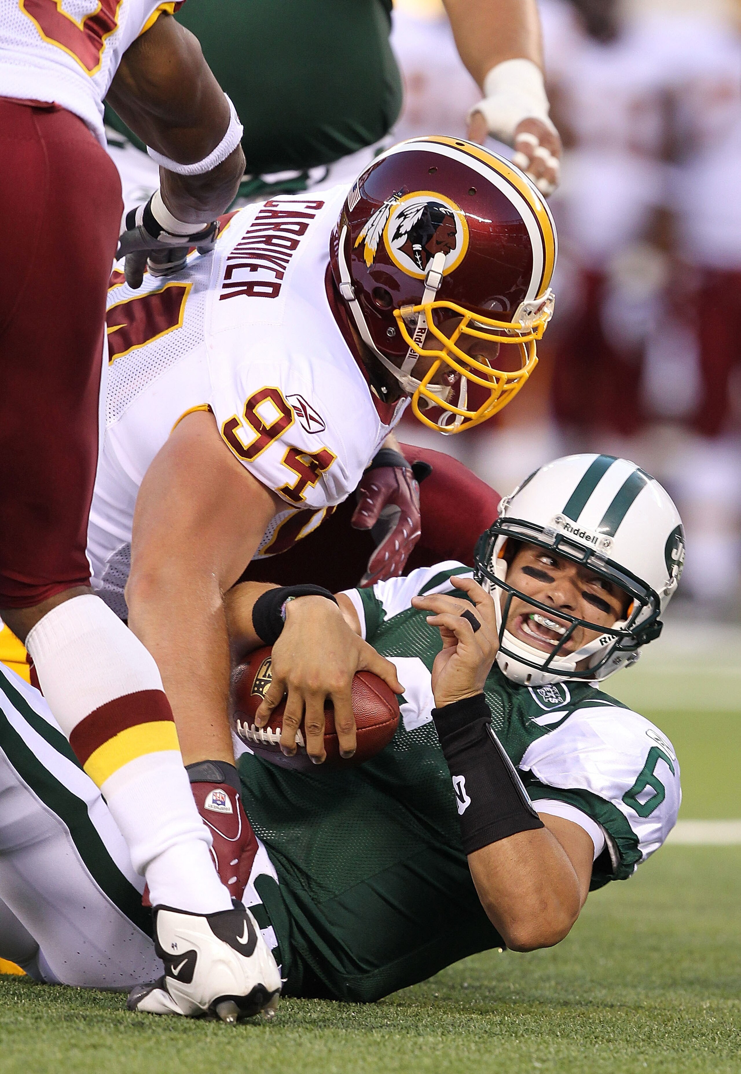 EAST RUTHERFORD, NJ - AUGUST 27:  Mark Sanchez #6 of the New York Jets is sacked by Adam Carriker #94 of the Washington Redskins  during their preseason game on August 27, 2010 at the New Meadowlands Stadium  in East Rutherford, New Jersey.  (Photo by Al