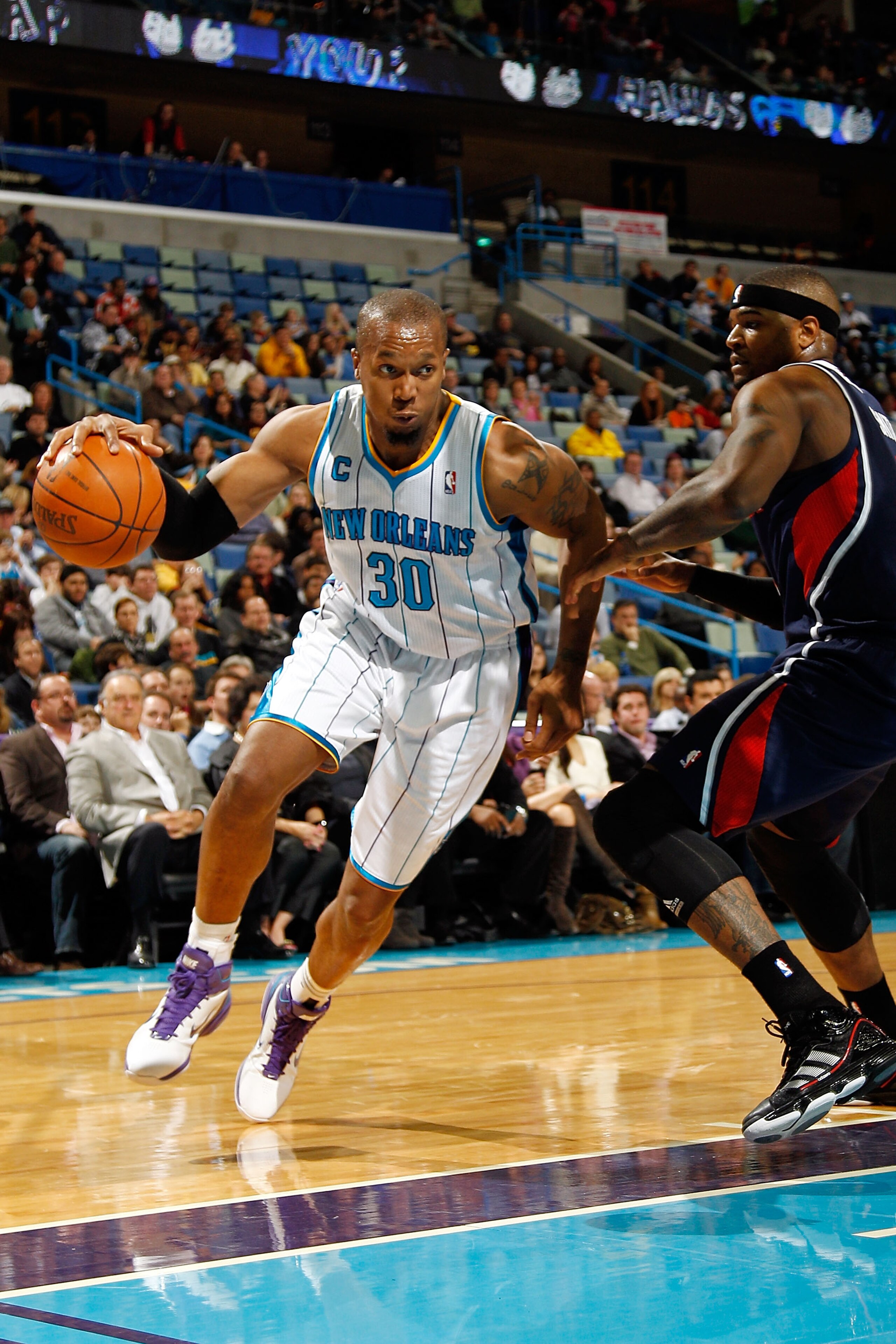 NEW ORLEANS, LA - DECEMBER 26:  David West #30 of the New Orleans Hornets drives the ball around Josh Smith #5 of the Atlanta Hawks at the New Orleans Arena on December 26, 2010 in New Orleans, Louisiana.  The Hornets defeated the Hawks 93-86.  NOTE TO US