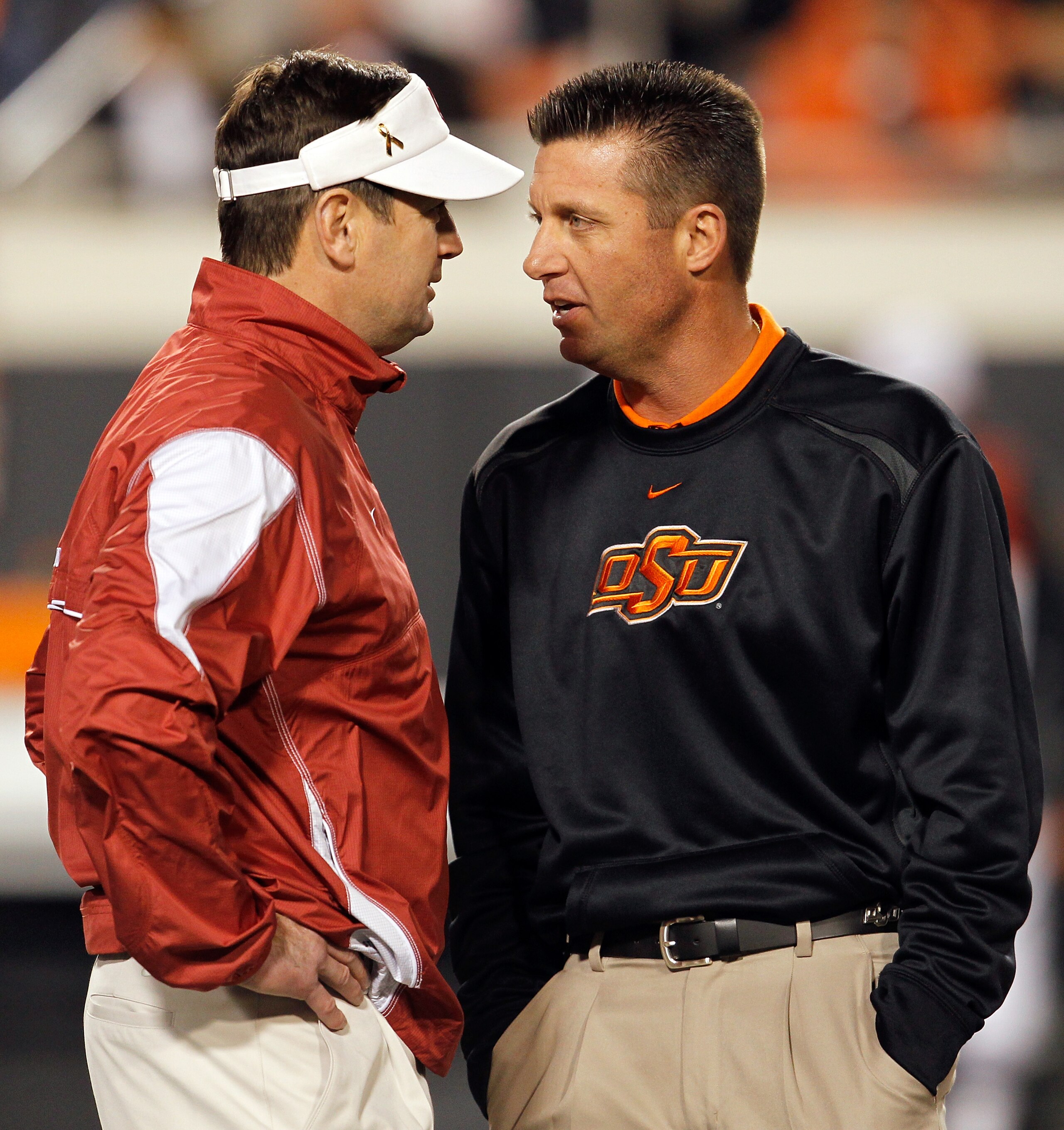 STILLWATER, OK - NOVEMBER 27:  Head coach Bob Stoops (L) of the Oklahoma Sooners talks with head coach Mike Gundy (R) of the Oklahoma State Cowboys at Boone Pickens Stadium on November 27, 2010 in Stillwater, Oklahoma.  (Photo by Tom Pennington/Getty Imag