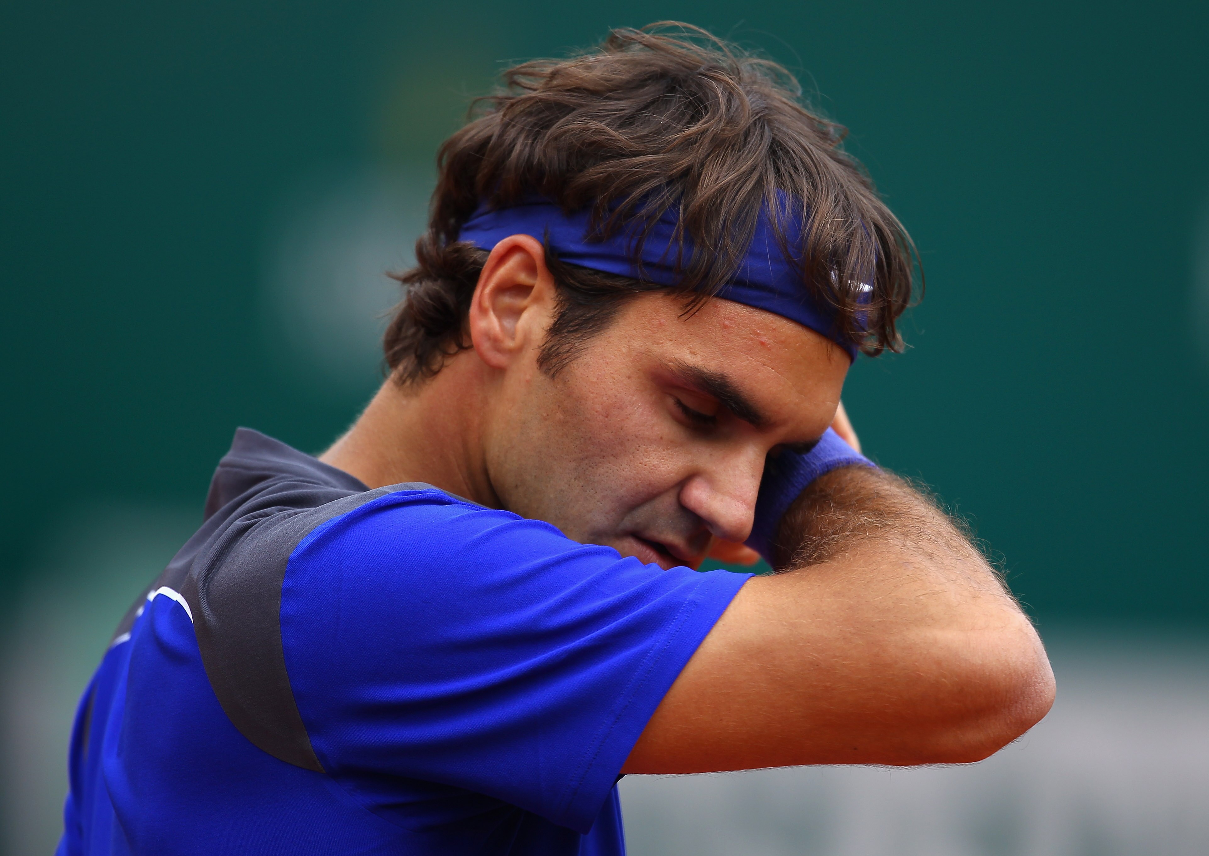 MONACO - APRIL 15:  Roger Federer of Switzerland wipes his face in his match against Jurgen Melzer of Austria during Day Six of the ATP Masters Series Tennis at the Monte Carlo Country Club on April 15, 2011 in Monte Carlo, Monaco.  (Photo by Julian Finne