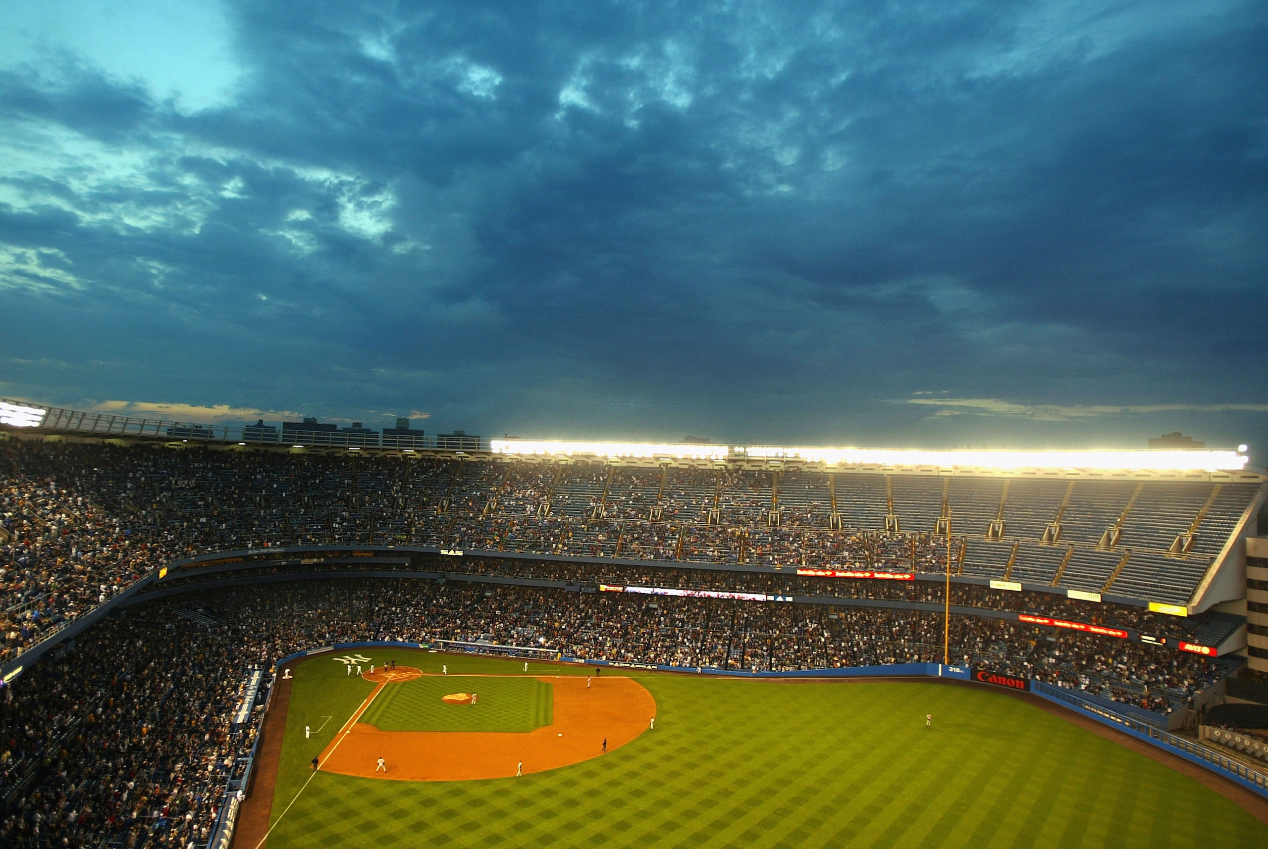 Hideki Matsui #55 of the New York Yankees heads to home plate after hitting a two-run home run that drove in teammate Jorge Posada in the second inning against the Baltimore Orioles as storm clouds loom in the sky  June 1, 2004 at Yankee Stadium in the Br