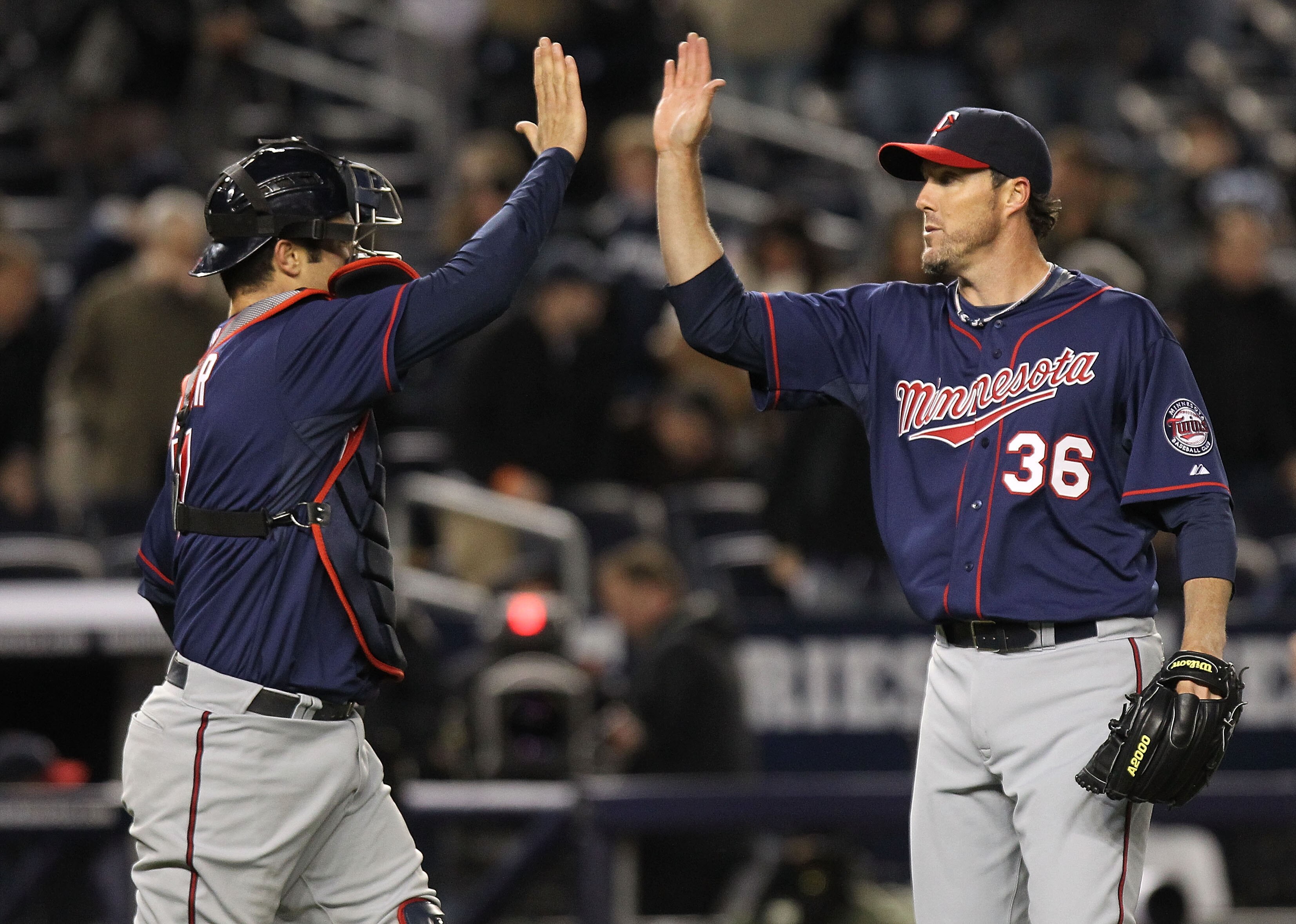 NEW YORK, NY - APRIL 05:  Joe Nathan #36 of the Minnesota Twins celebrates the win with Joe Mauer #7 against the New York Yankees at Yankee Stadium on April 5, 2011 in the Bronx borough of New York City.  (Photo by Nick Laham/Getty Images)