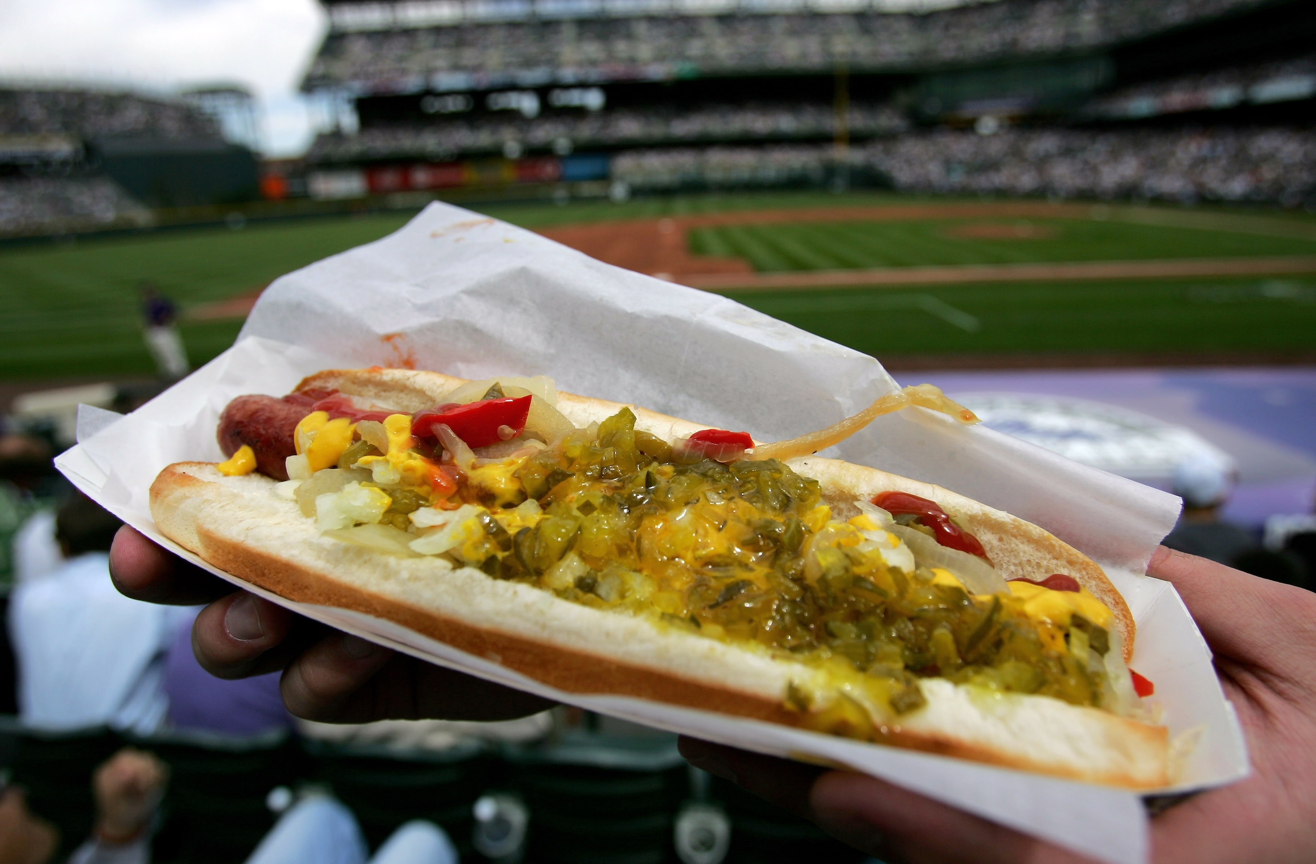 DENVER - APRIL 02:  A fan has a loaded hotdog at the ready to celebrate Opening Day as the Arizona Diamondbacks face off against the Colorado Rockies on April 2, 2007 at Coors Field in Denver, Colorado.  (Photo by Doug Pensinger/Getty Images)
