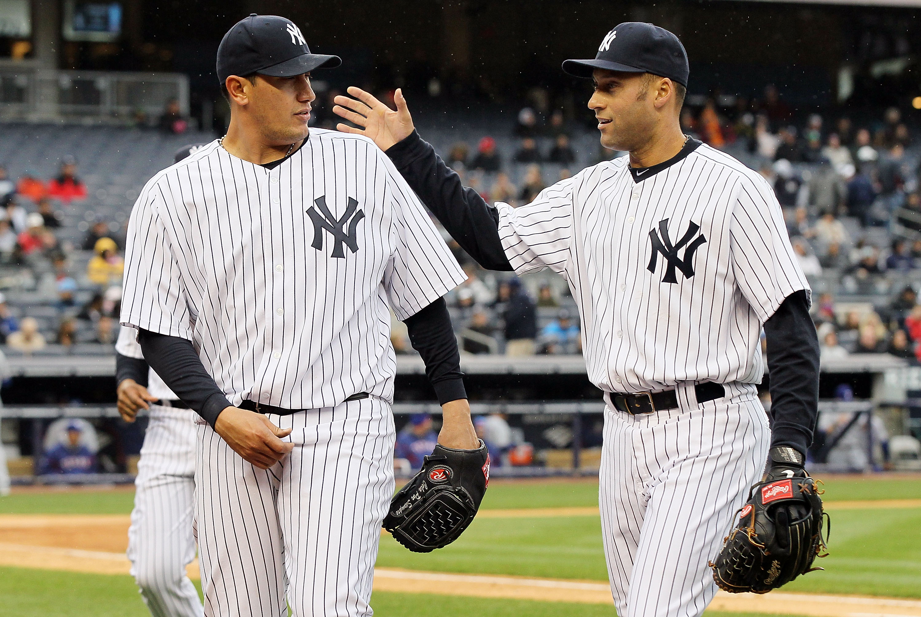 NEW YORK, NY - APRIL 16:  Freddy Garcia #36 and Derek Jeter #2 of the New York Yankees celebrate the final out of an inning against the Texas Rangers on April 16, 2011 at Yankee Stadium in the Bronx borough of New York City.  (Photo by Jim McIsaac/Getty I