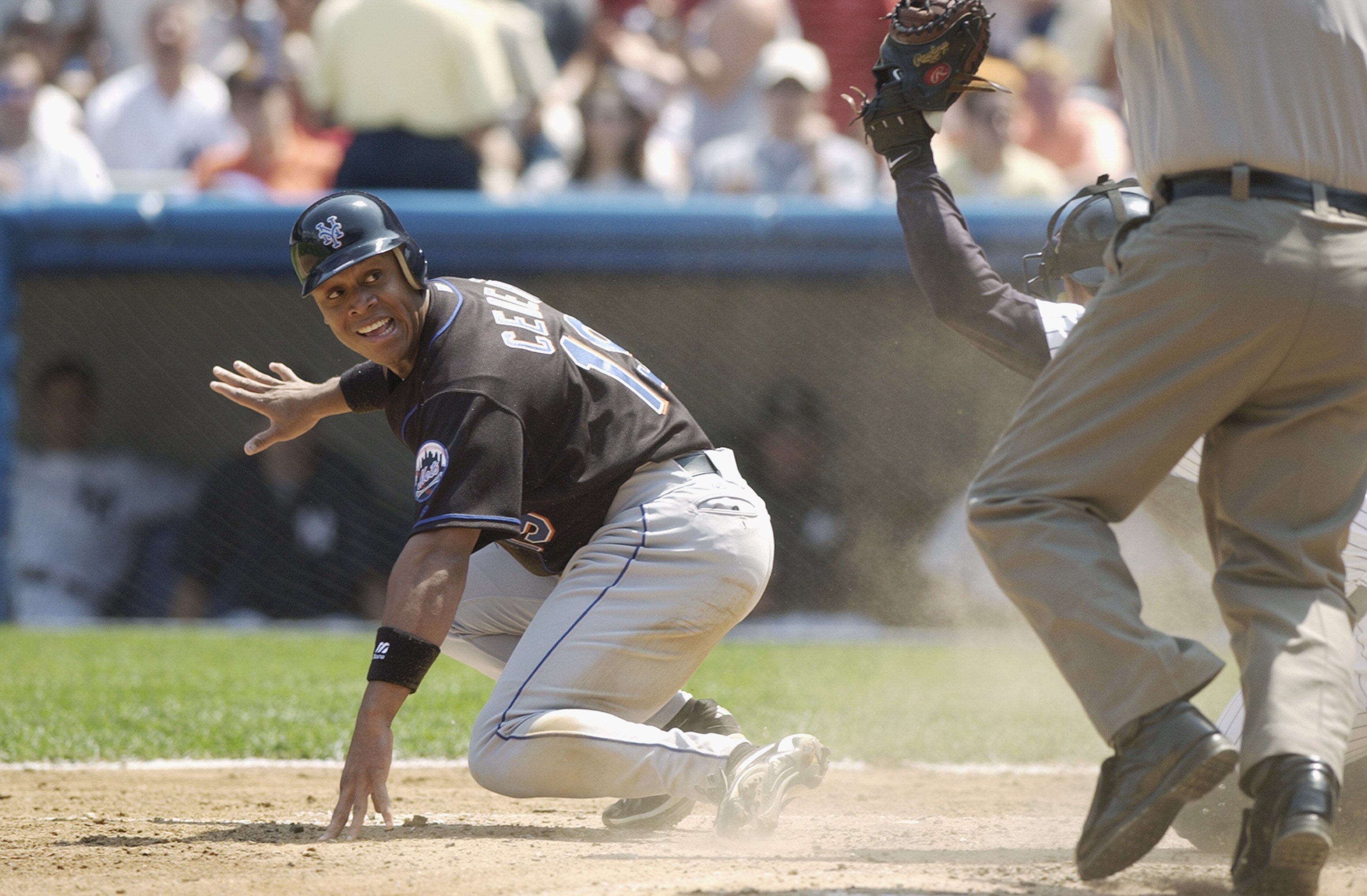 BRONX, NY - JUNE 29:  Leftfielder Roger Cedeno #19 of the New York Mets looks to home plate umpire Larry Young for the call after sliding into home against catcher Alberto Castillo #45 of the New York Yankees who shows he still has the ball in his glove d