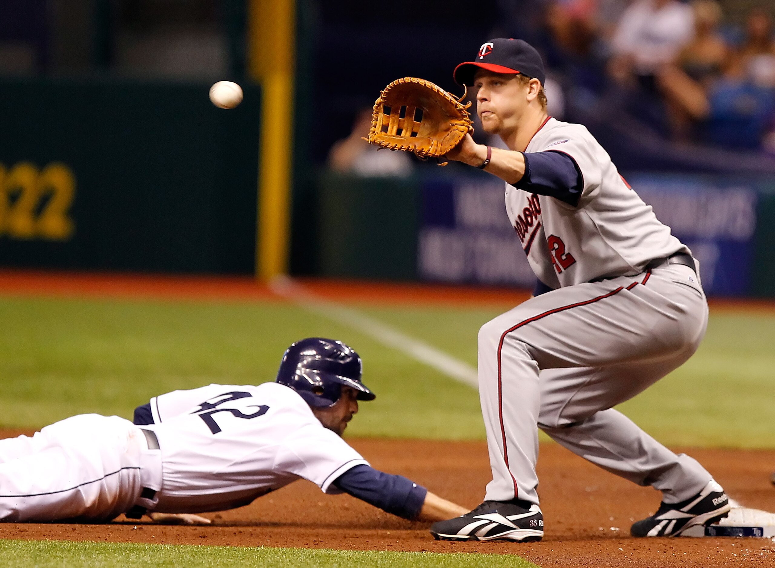 ST. PETERSBURG, FL - APRIL 15:  First baseman Justin Morneau #33 of the Minnesota Twins takes the throw at first as outfielder Sam Fuld #5 of the Tampa Bay Rays gets back safely during the game at Tropicana Field on April 15, 2011 in St. Petersburg, Flori