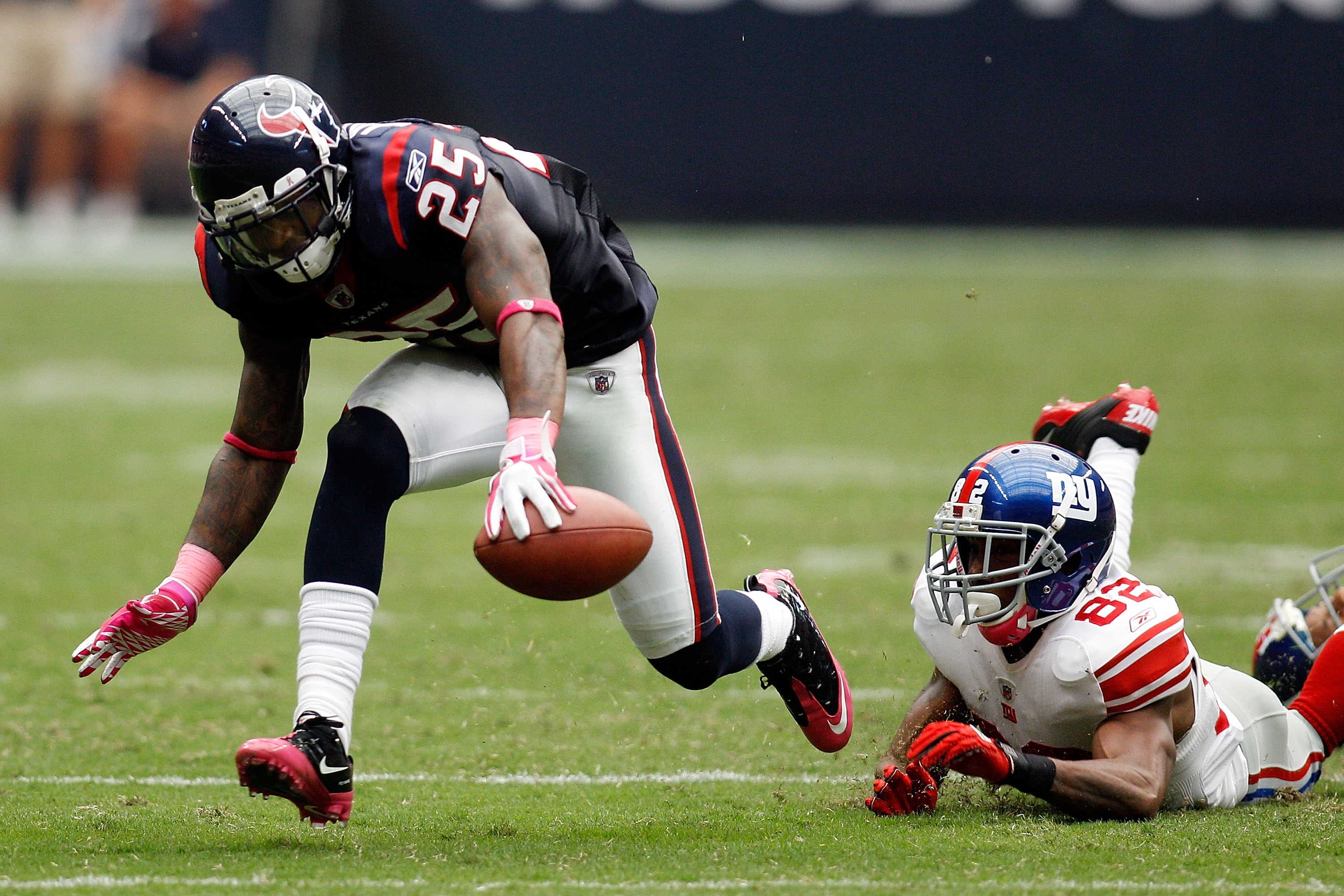 HOUSTON - OCTOBER 10:  Kareem Jackson #25 of the Houston Texans avoids a tackle after intercepting a pass  by Mario Manningham #82 of the New York Giants at Reliant Stadium on October 10, 2010 in Houston, Texas.  The Giants defeated the Texans 34-10.  (Ph
