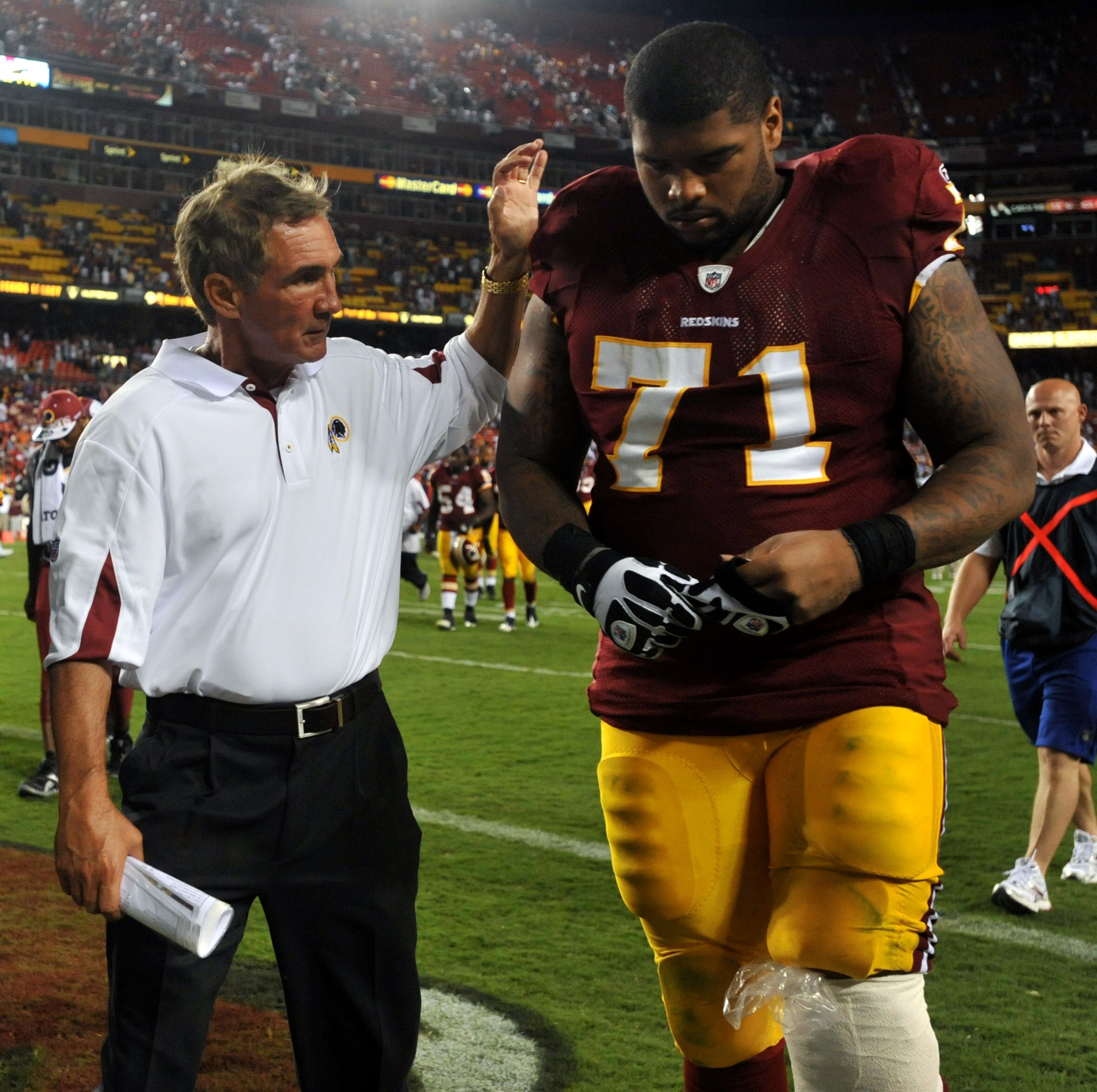 LANDOVER - SEPTEMBER 19:  Trent Williams #71 of the Washington Redskins is consoled by head coach Mike Shanahan during the game against the Houston Texans at FedExField on September 19, 2010 in Landover, Maryland. The Texans defeated the Redskins in overt
