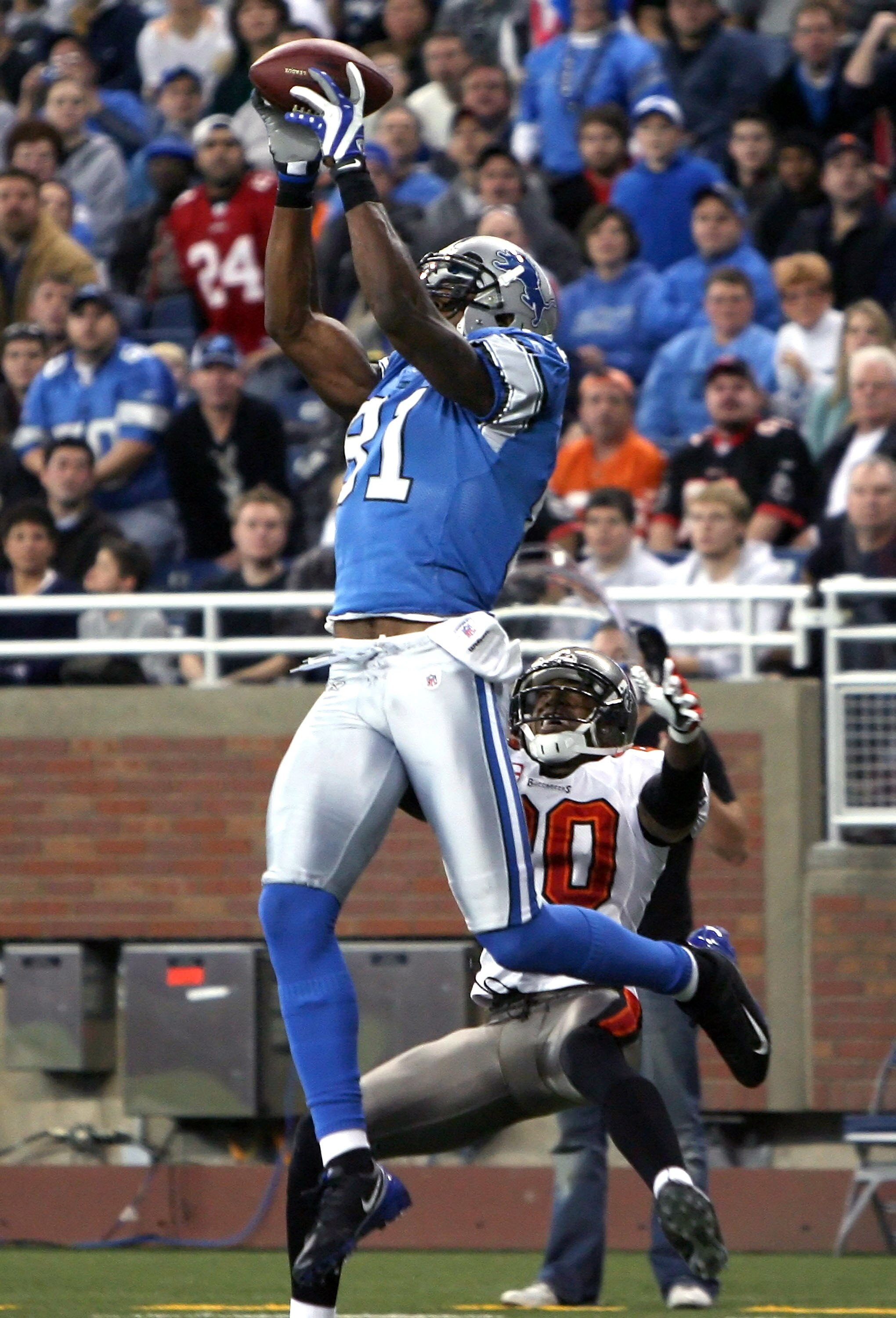 DETROIT - NOVEMBER 23:  Wide receiver Calvin Johnson #81 of the Detroit Lions catches a 15 yard touchdown reception over Ronde Barber #20 of the Tampa Bay Buccaneers during the first quarter of the NFL game at Ford Field on November 23, 2008 in Detroit, M