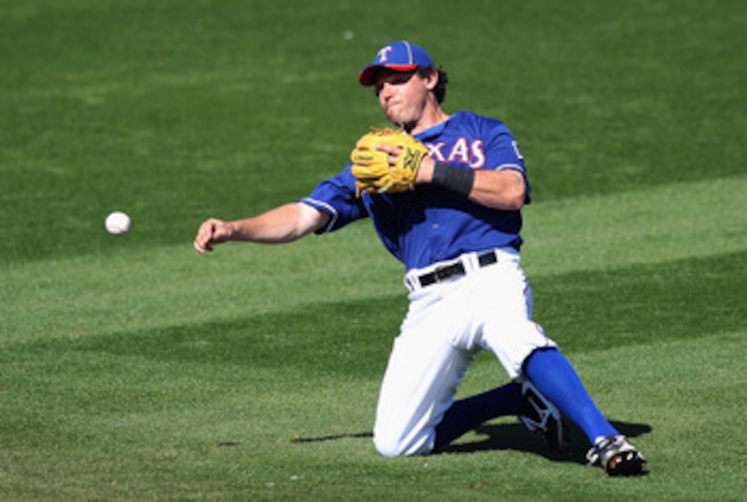 SURPRISE, AZ - MARCH 02:  Infielder Ian Kinsler #5 of the Texas Rangers fields a ground ball out against the Los Angeles Angels of Anaheim during the spring training game at Surprise Stadium on March 2, 2011 in Surprise, Arizona.  (Photo by Christian Pete