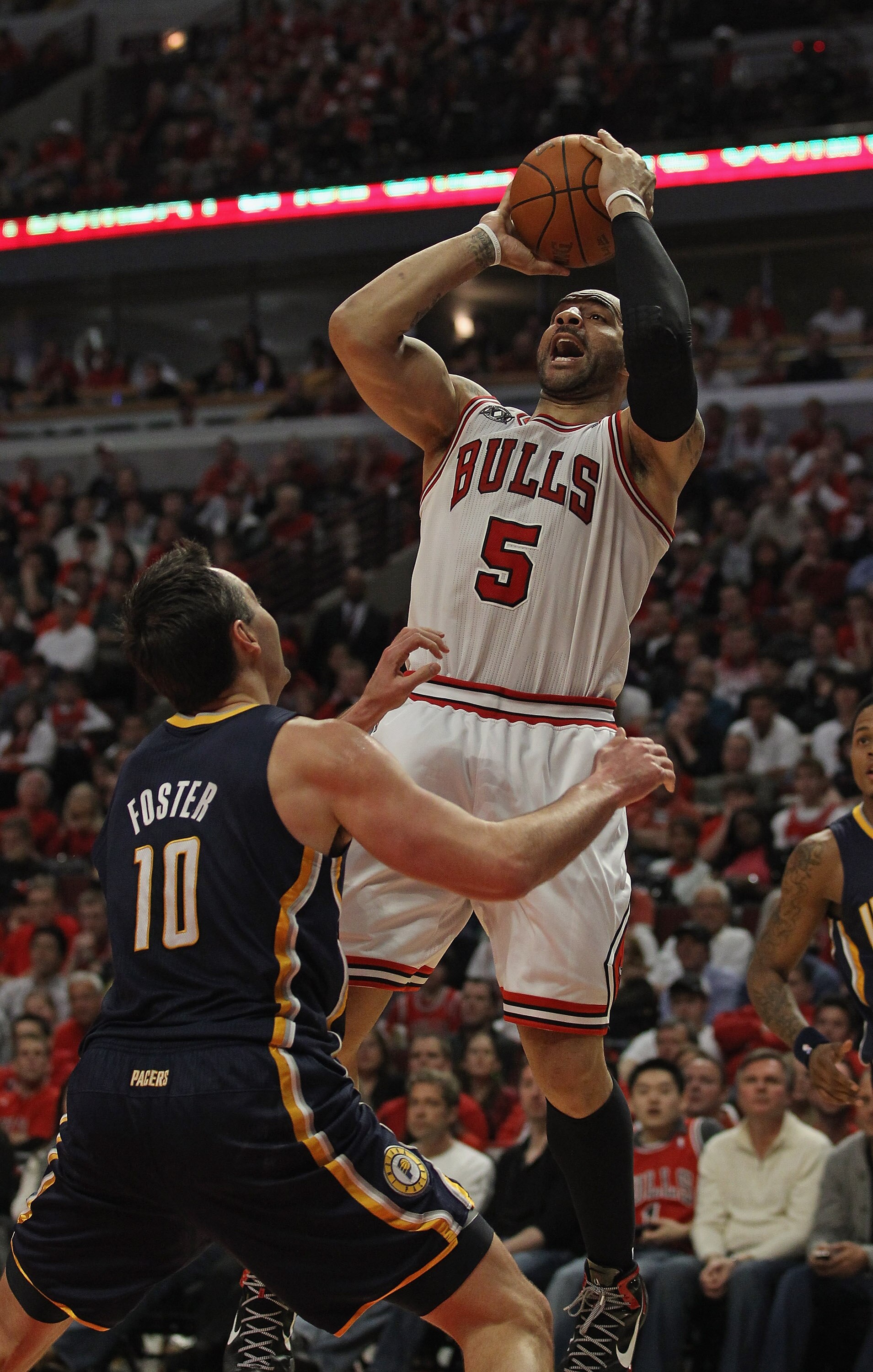 CHICAGO, IL - APRIL 16: Carlos Boozer #5 of the Chicago Bulls puts up a shot over Jeff Foster #10 of the Indiana Pacers in Game One of the Eastern Conference Quarterfinals in the 2011 NBA Playoffs at the United Center on April 16, 2011 in Chicago, Illinoi