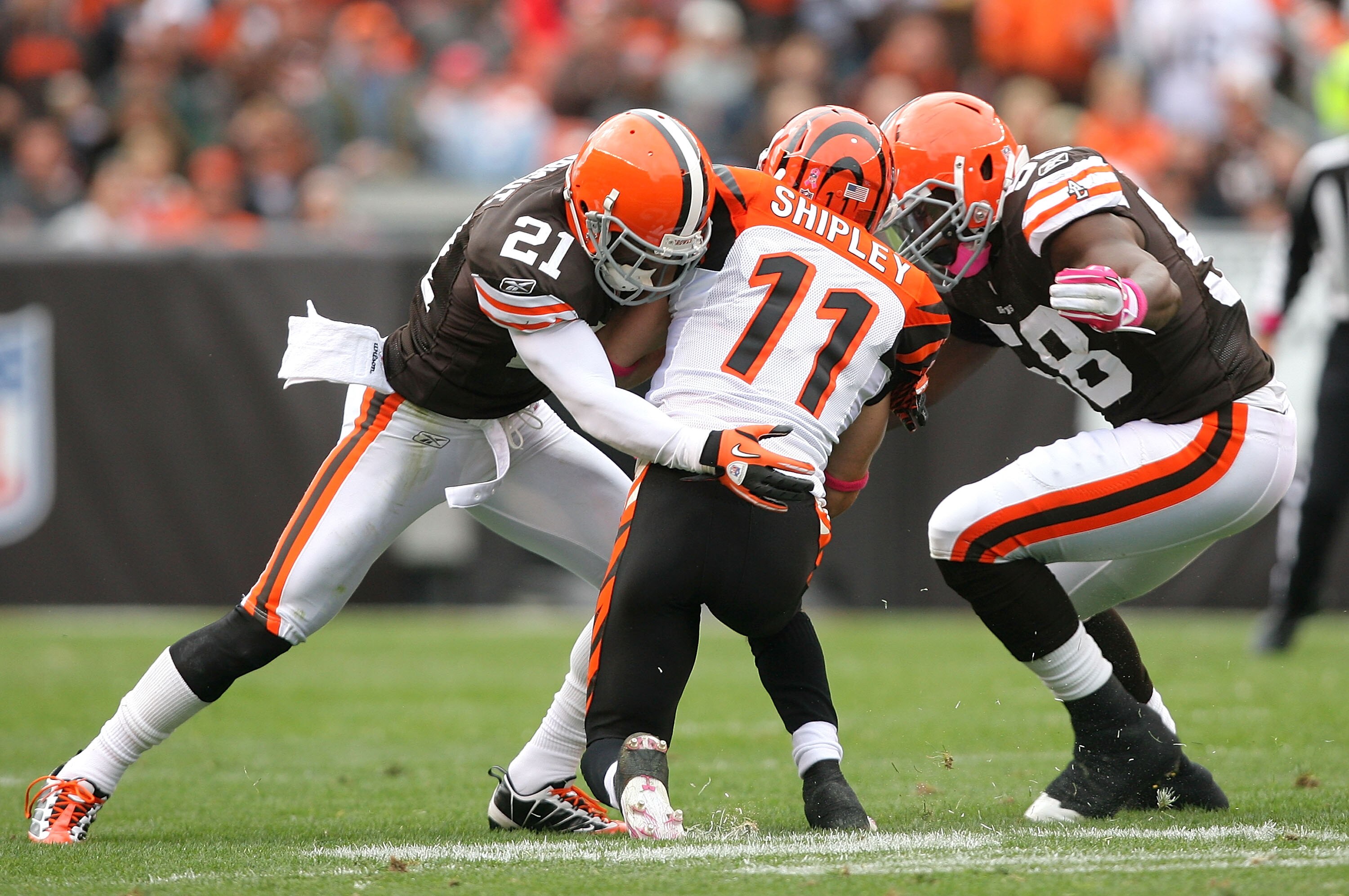 CLEVELAND - OCTOBER 03:  Defenders Eric Wright #21 and Marcus Benard #58 of the Cleveland Browns tackle wide receiver Jordan Shipley #11 of the Cincinnati Bengals at Cleveland Browns Stadium on October 3, 2010 in Cleveland, Ohio.  (Photo by Matt Sullivan/