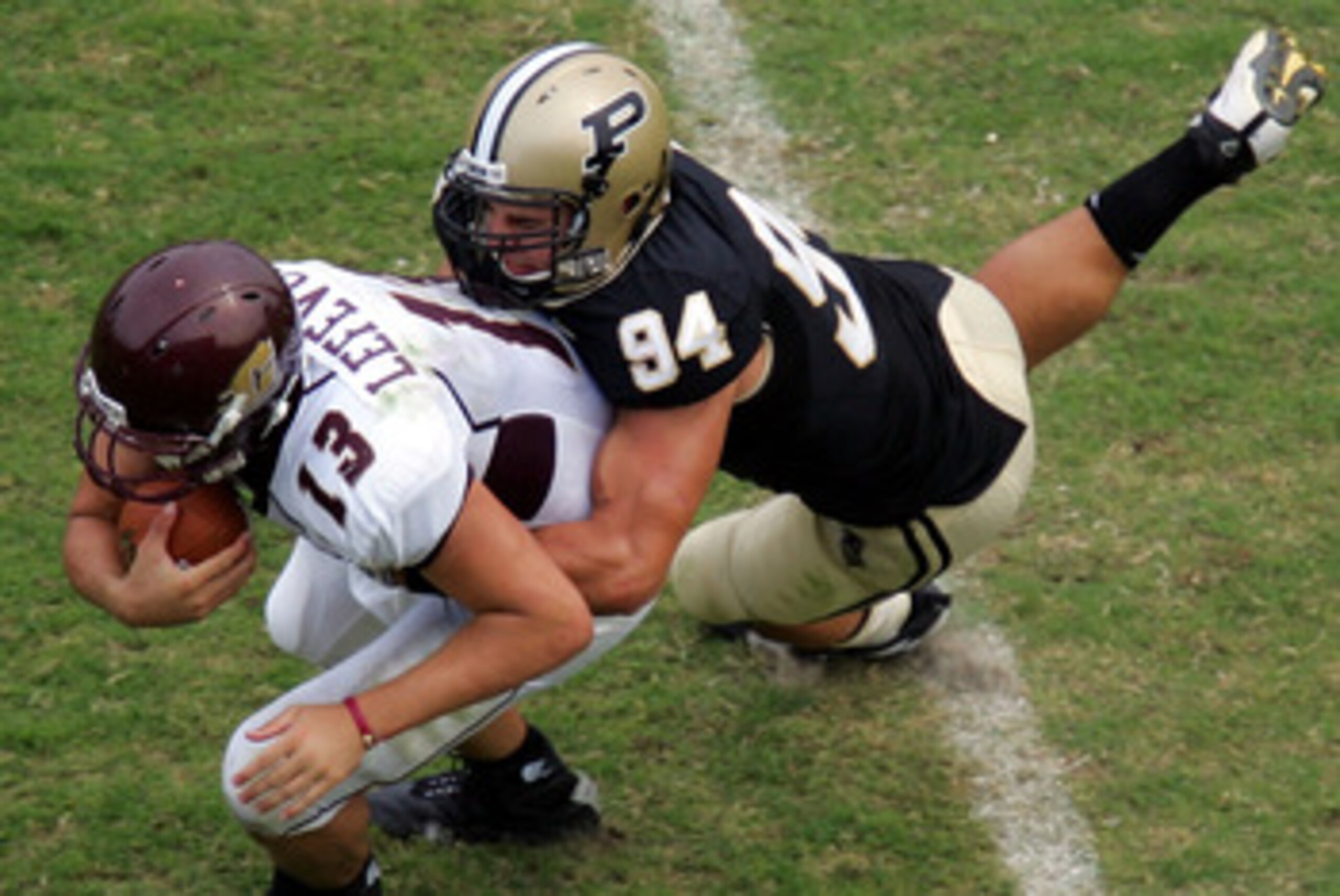 WEST LAFAYETTE, IN - SEPTEMBER 20:  Quarterback Dan LeFevour #13 of the Central Michigan Chippewas is tackled by Ryan Kerrigan #94 of the Purdue Boilermakers at Ross-Ade Stadium on September 20, 2008 in West Lafayette, Indiana.  (Photo by Ronald Martinez/