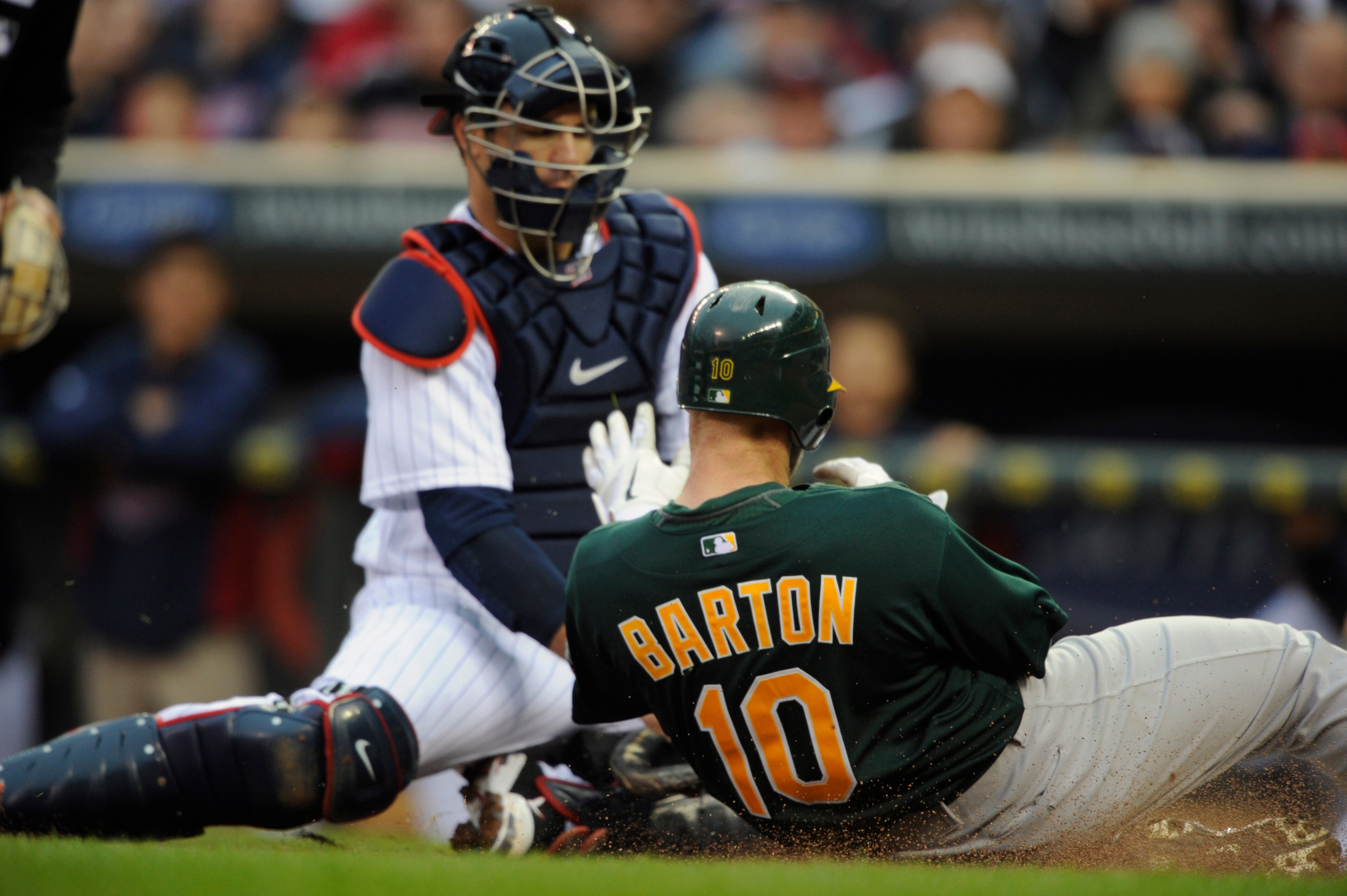 MINNEAPOLIS, MN - APRIL 9: Catcher Joe Mauer #7 of the Minnesota Twins tags out Daric Barton #10 of the Oakland Athletics during the first inning of their game on April 9, 2011 at Target Field in Minneapolis, Minnesota. (Photo by Hannah Foslien/Getty Imag