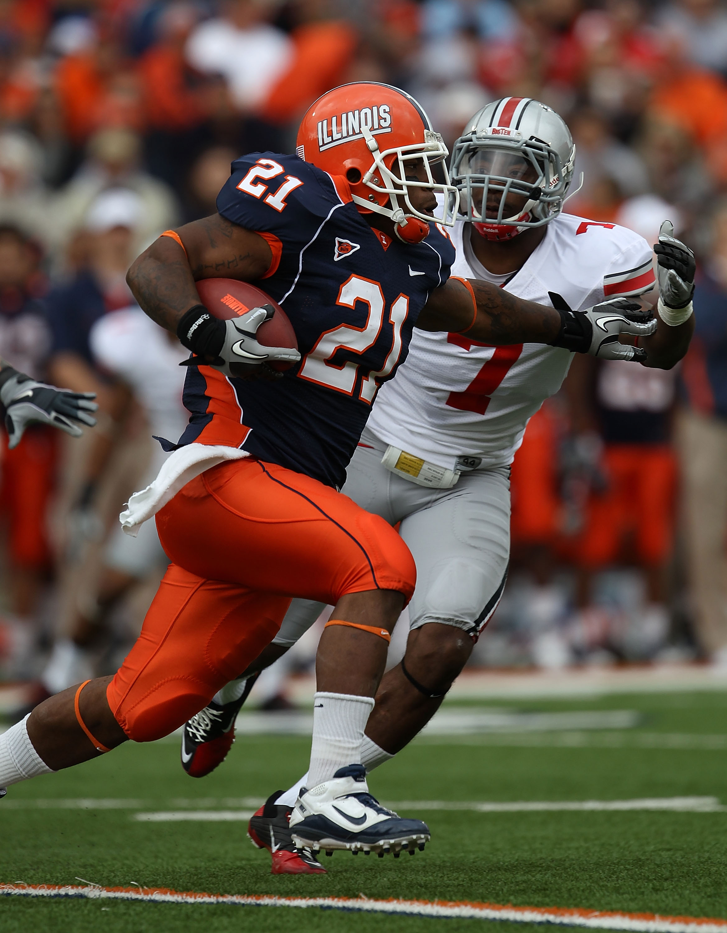 CHAMPAIGN, IL - OCTOBER 02: Jason Ford #21 of the Illinois Fighting Illini runs past Jermale Hines #7 of the Ohio State Buckeyes at Memorial Stadium on October 2, 2010 in Champaign, Illinois. Ohio State defeated Illinois 24-13. (Photo by Jonathan Daniel/G