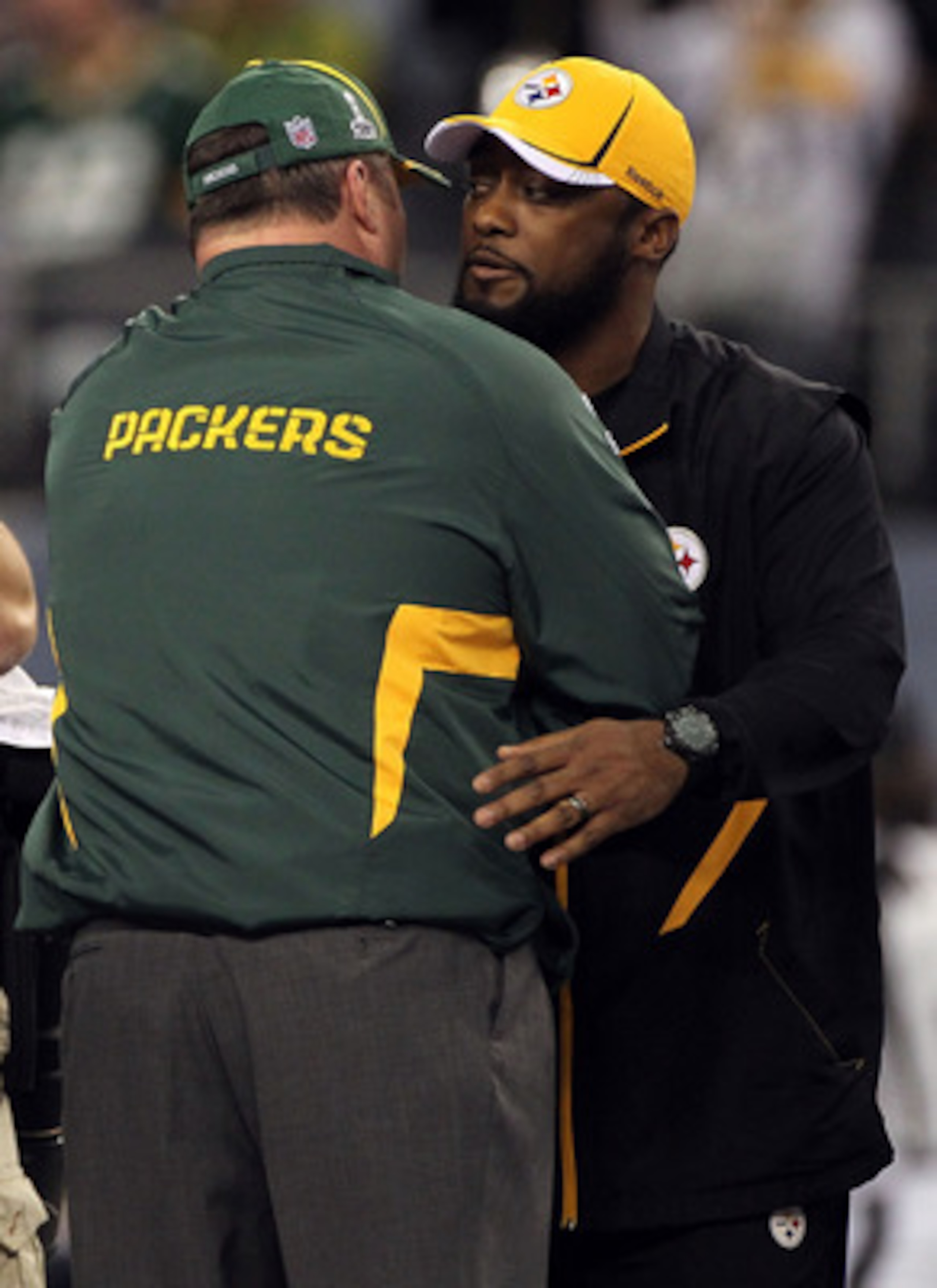 ARLINGTON, TX - FEBRUARY 06:  Head coach Mike Tomlin of the Pittsburgh Steelers (R) and head coach Mike McCarthy of the Green Bay Packers speak before Super Bowl XLV at Cowboys Stadium on February 6, 2011 in Arlington, Texas.  (Photo by Doug Pensinger/Get