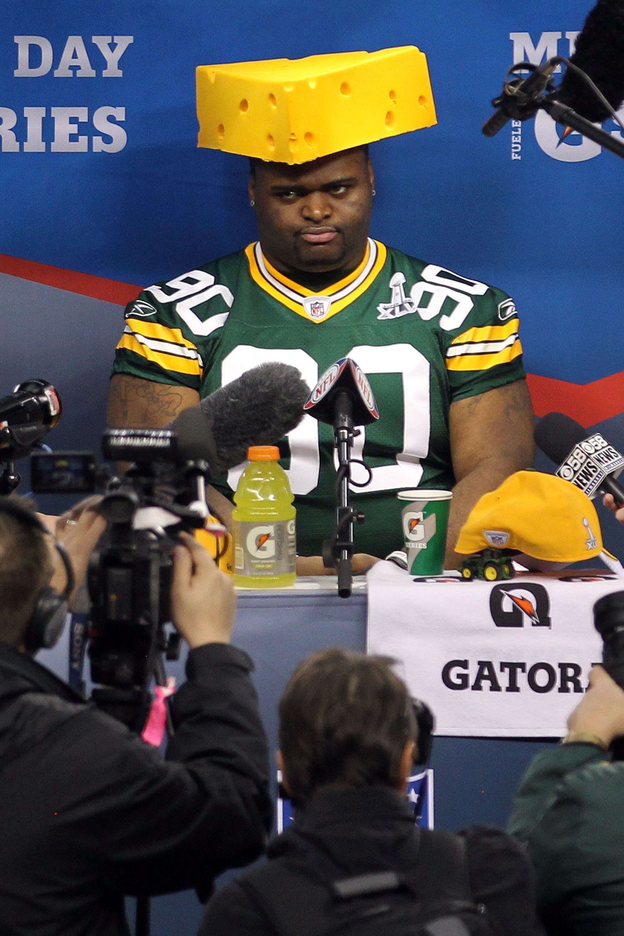 ARLINGTON, TX - FEBRUARY 01:  B.J. Raji #90 of the Green Bay Packers puts on a cheesehead during Super Bowl XLV Media Day ahead of Super Bowl XLV at Cowboys Stadium on February 1, 2011 in Arlington, Texas. The Pittsburgh Steelers will play the Green Bay P