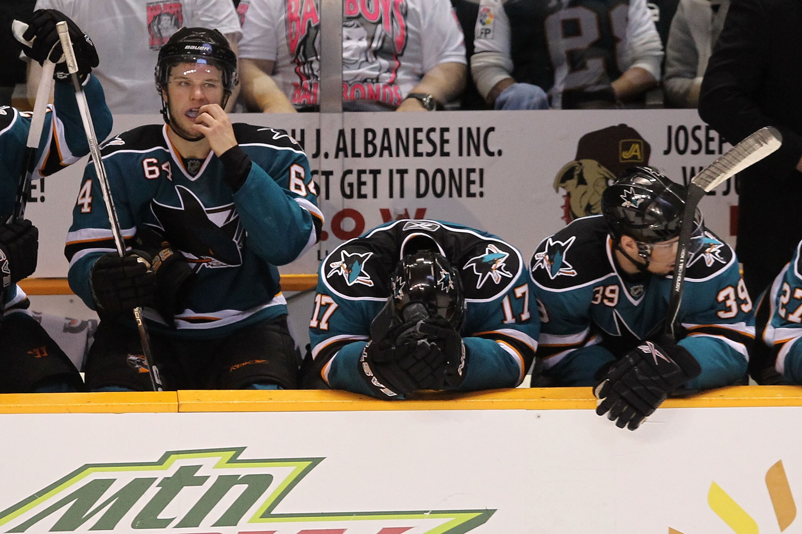 SAN JOSE, CA - MAY 18: (L-R) Jamie McGinn #64, Torrey Mitchell #17 and Logan Couture #39 of the San Jose Sharks on the bench late in the fourth period before losing to the Chicago Blackhawks 4-2 in Game Two of the Western Conference Finals during the 201 SAN JOSE, CA - MAY 18: (L-R) Jamie McGinn #64, Torrey Mitchell #17 and Logan Couture #39 of the San Jose Sharks on the bench late in the fourth period before losing to the Chicago Blackhawks 4-2 in Game Two of the Western Conference Finals during the 201