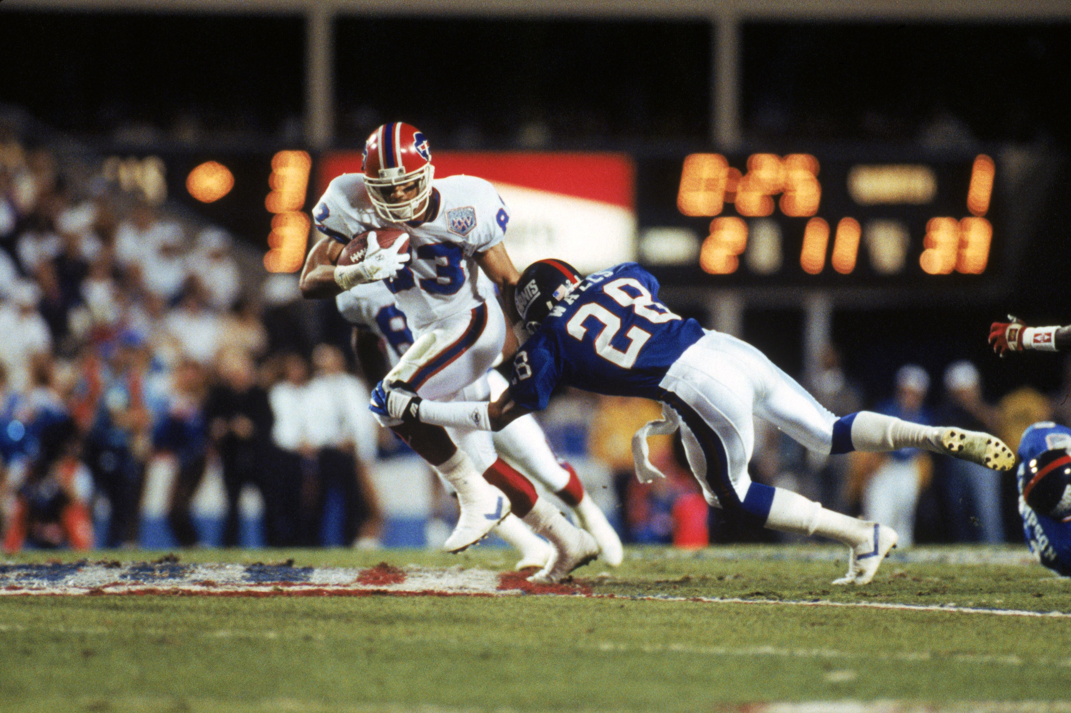 TAMPA, FL - JANUARY 27:  Wide receiver Andre Reed #83 of the Buffalo Bills tries to break away from a tackle by cornerback Everson Walls #28 of the New York Giants on a twenty yard pass in Super Bowl XXV at Tampa Stadium on January 27, 1991 in Tampa, Flor
