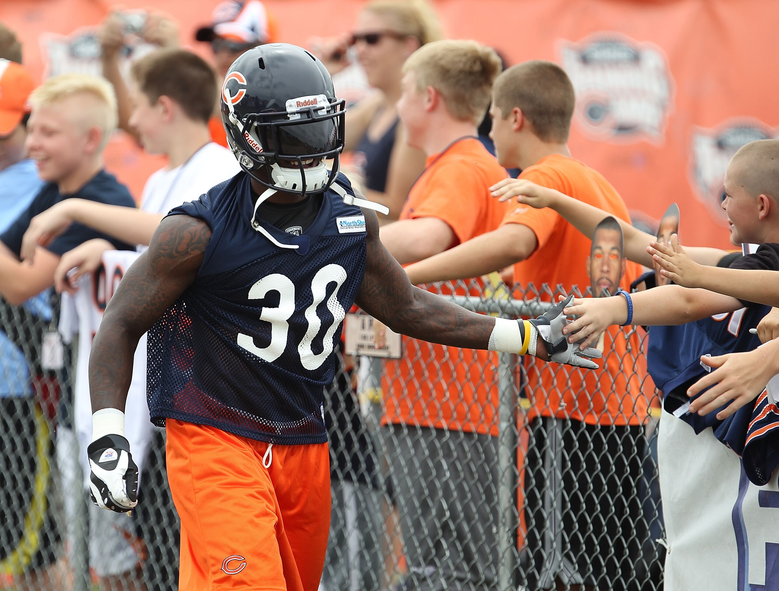 BOURBONNAIS, IL - JULY 30: D.J. Moore #30 of the Chicago Bears shakes hands with fans on his way out to the field for a summer training camp practice at Olivet Nazarene University on July 30, 2010 in Bourbonnais, Illinois. (Photo by Jonathan Daniel/Getty