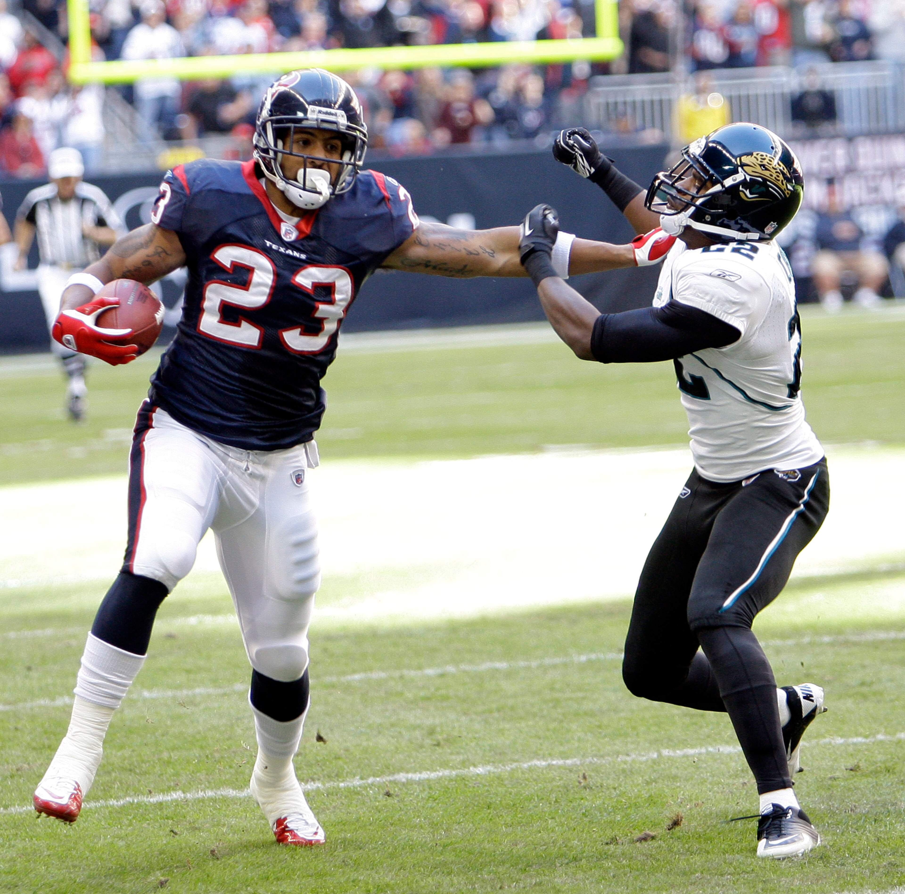 HOUSTON - JANUARY 02:  Running back Arian Foster #23 of the Houston Texans gives Don Carey #22 of the Jacksonville Jaguars a stiff arm at Reliant Stadium on January 2, 2011 in Houston, Texas.  (Photo by Bob Levey/Getty Images)