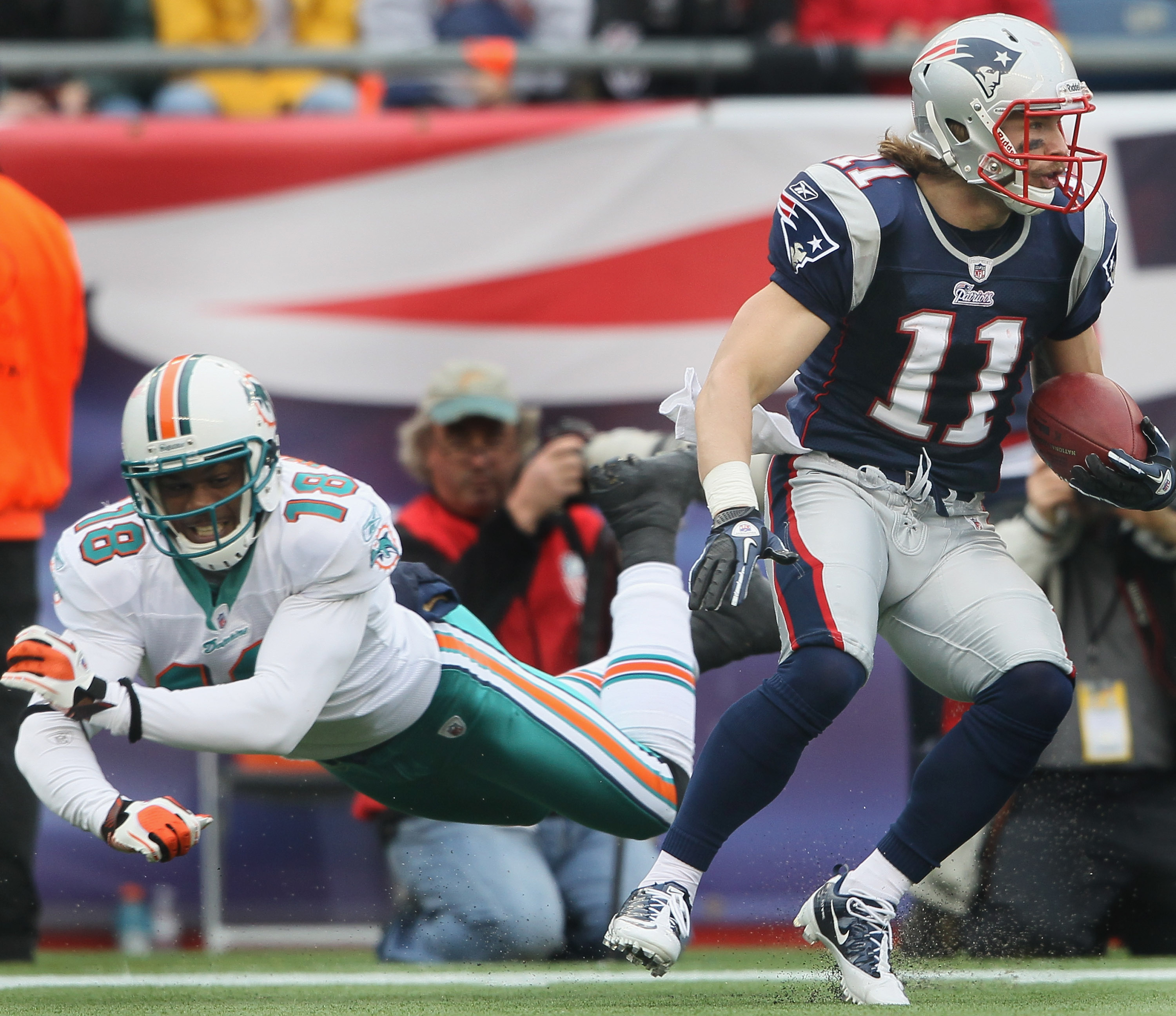 FOXBORO, MA - JANUARY 02:  Julian Edleman #11 of the New England Patriots avoids Roberto Wallace #18 of the Miami Dolphins on January 2, 2011 at Gillette Stadium in Foxboro, Massachusetts.  (Photo by Elsa/Getty Images)